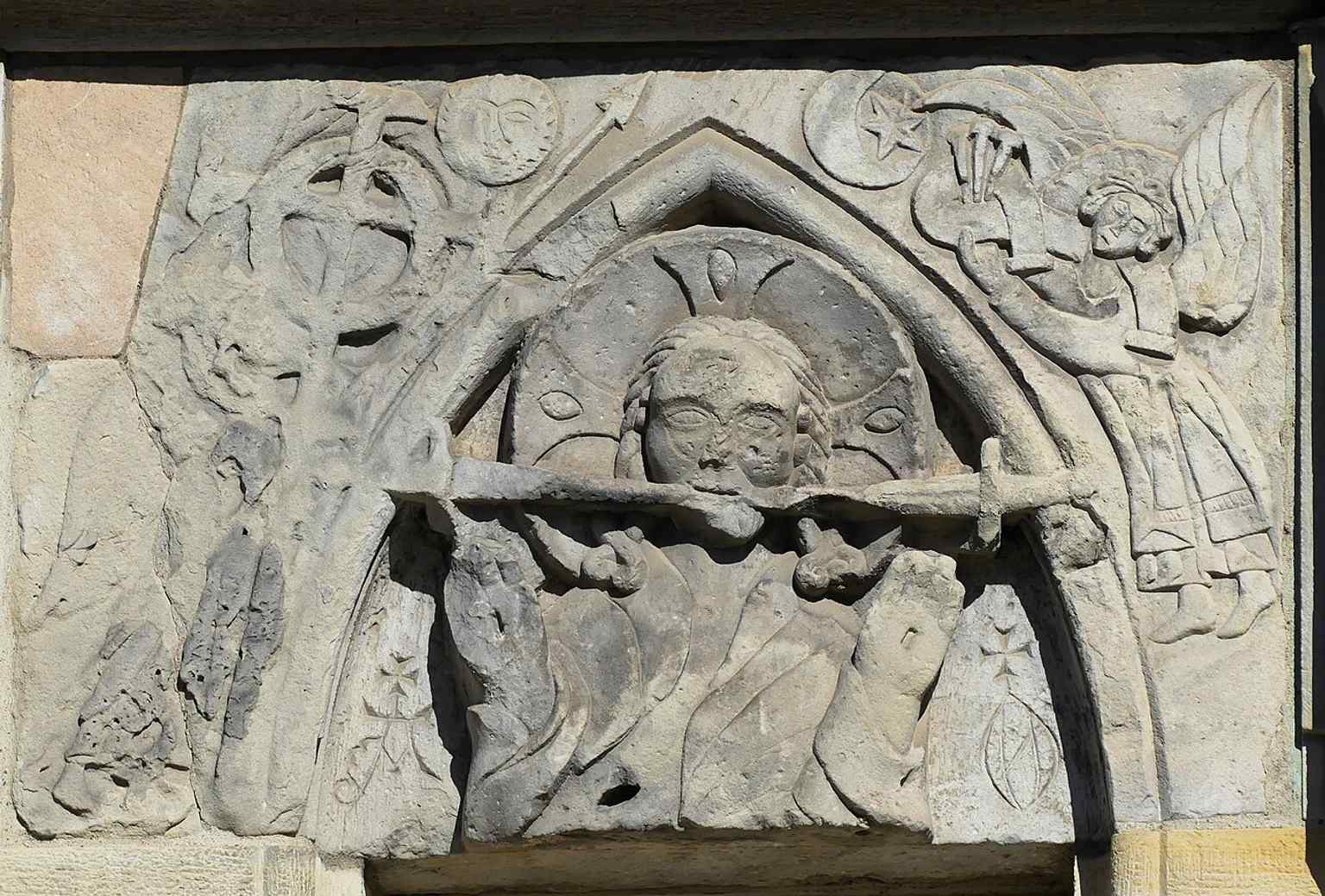 The north portal relief of Christ blessing, a medieval carving from about 1290–1310 that survives on the church’s western side.