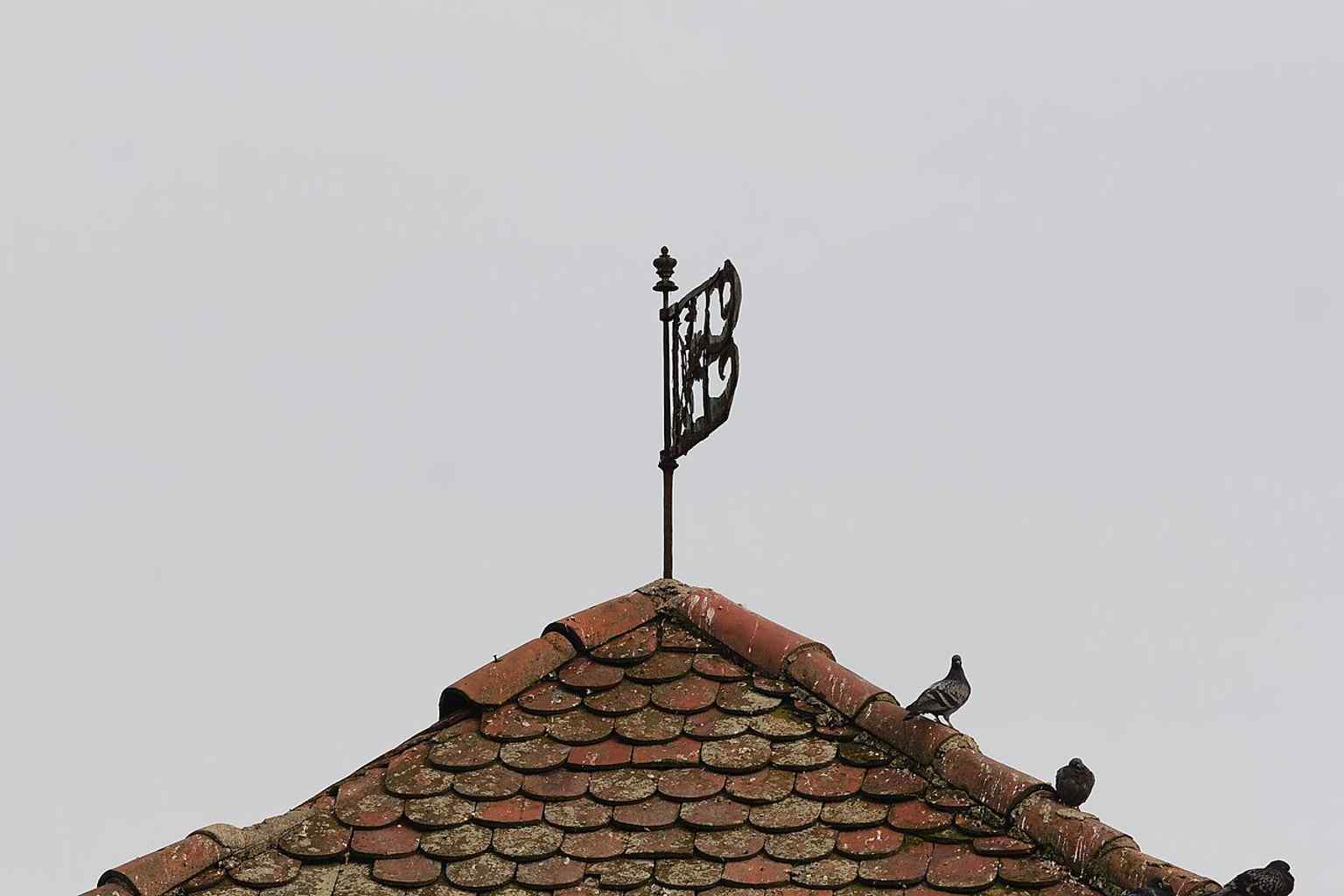 Close view of the tower’s roof and weather vane — a good detail shot for the 1864 reroofing and later preservation history.