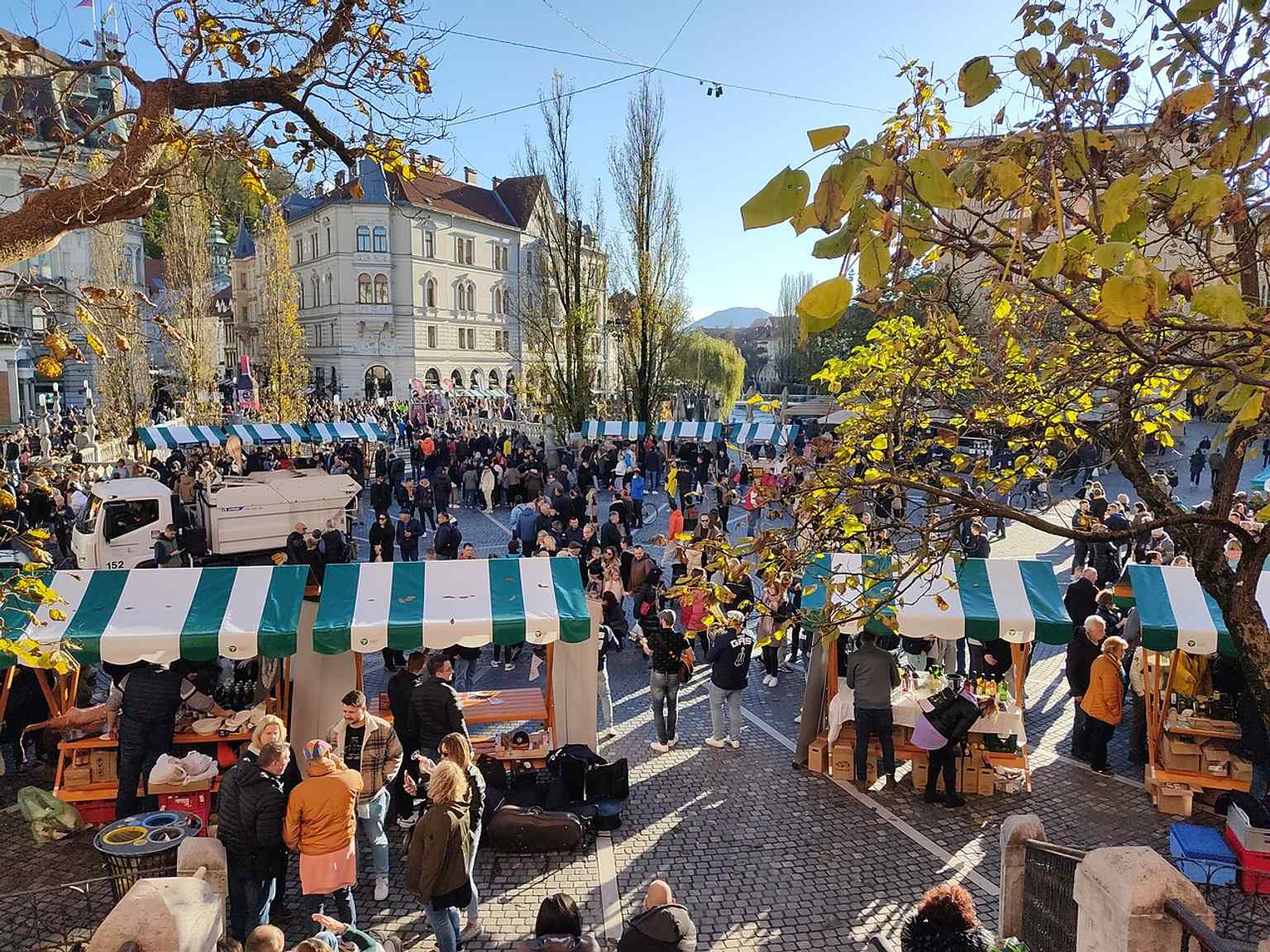 A street-level view of Prešeren Square, showcasing the Hauptmann House at number 1, which features a distinctive facade renovated in 1904 in the Viennese Secession style, adorned with colorful ceramic tiles.