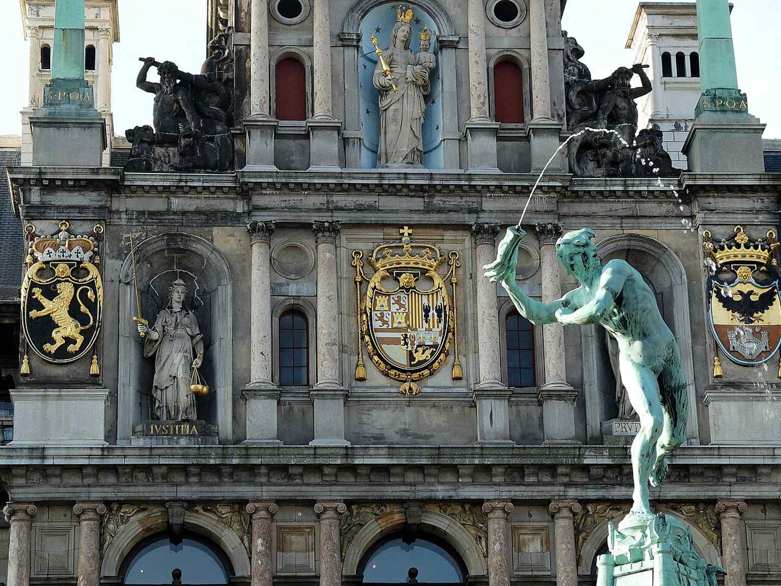 The carved coat-of-arms reliefs on the façade reflect the political powers that shaped Antwerp’s history, from Brabant to the Spanish Habsburgs.
