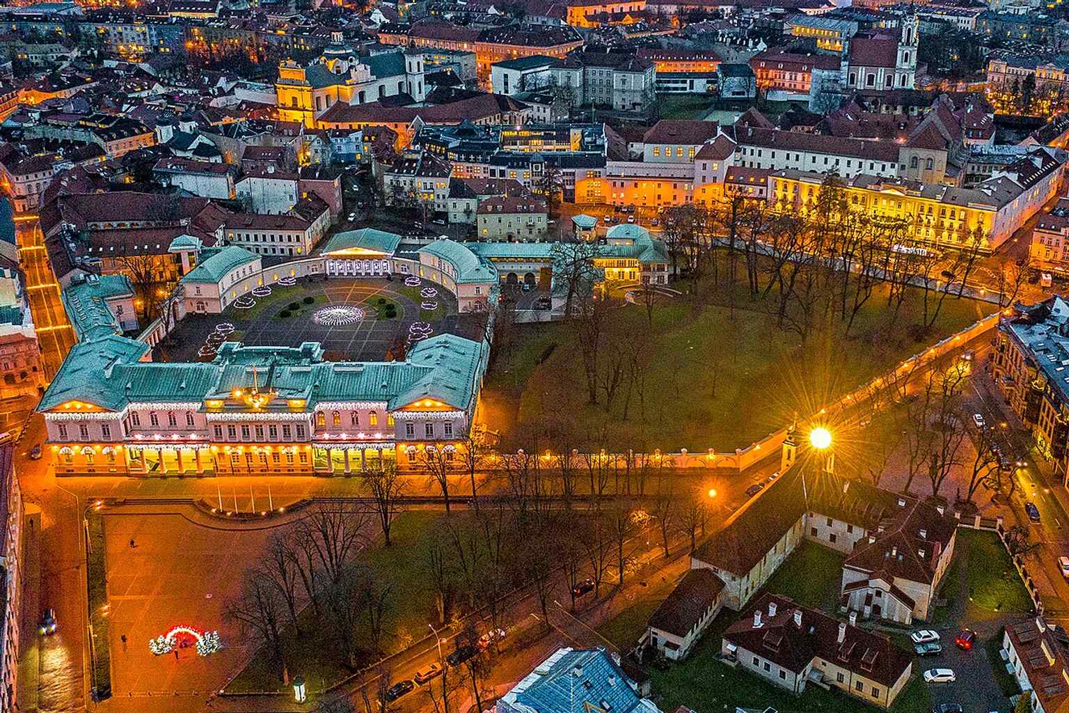 A night view of the Prezidentūra emphasizes its prominent presence on Simonas Daukantas Square, named after the Lithuanian historian who helped shape national identity.