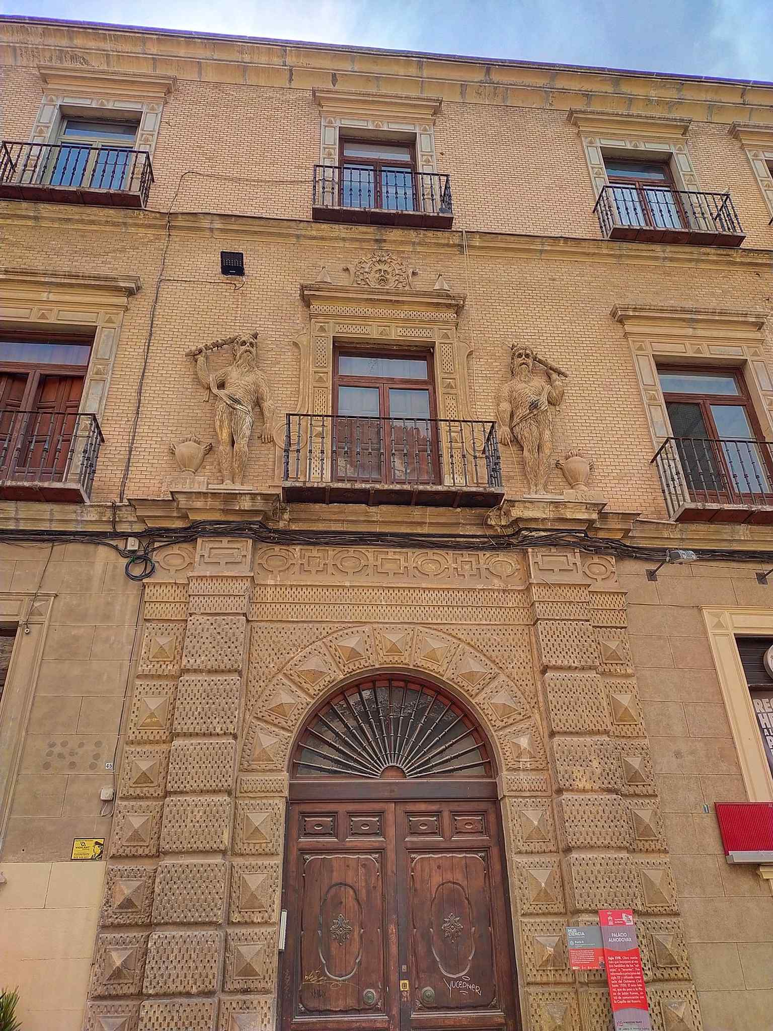 Observe the distinctive facade of the Almodóvar Palace, featuring "salvajes" (giants) on either side of the main balcony, a heraldic motif that prefigures Baroque architecture.