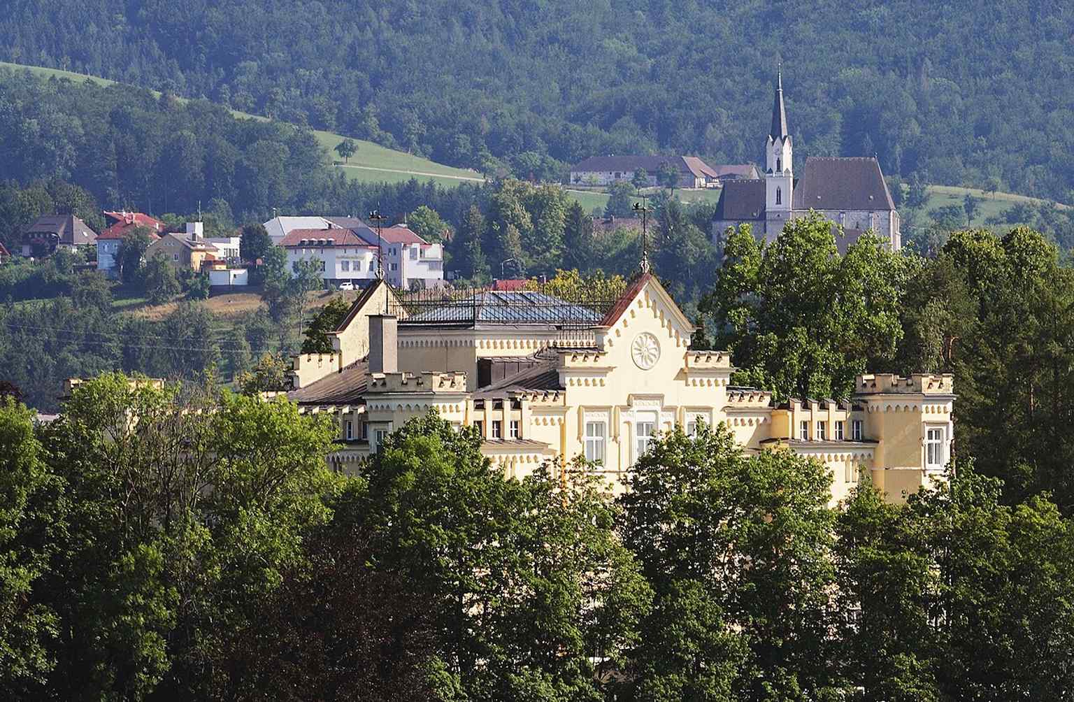 A telephoto panorama placing Voglsang Castle in the wider city context, with St. Ulrich Church visible behind it.