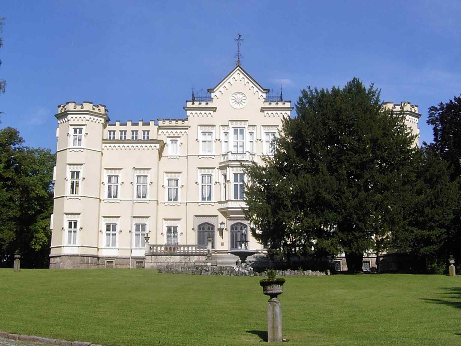 Seen from the street side with the park and fountain, matching the historic setting of Schloss Voglsang as a villa with grounds.