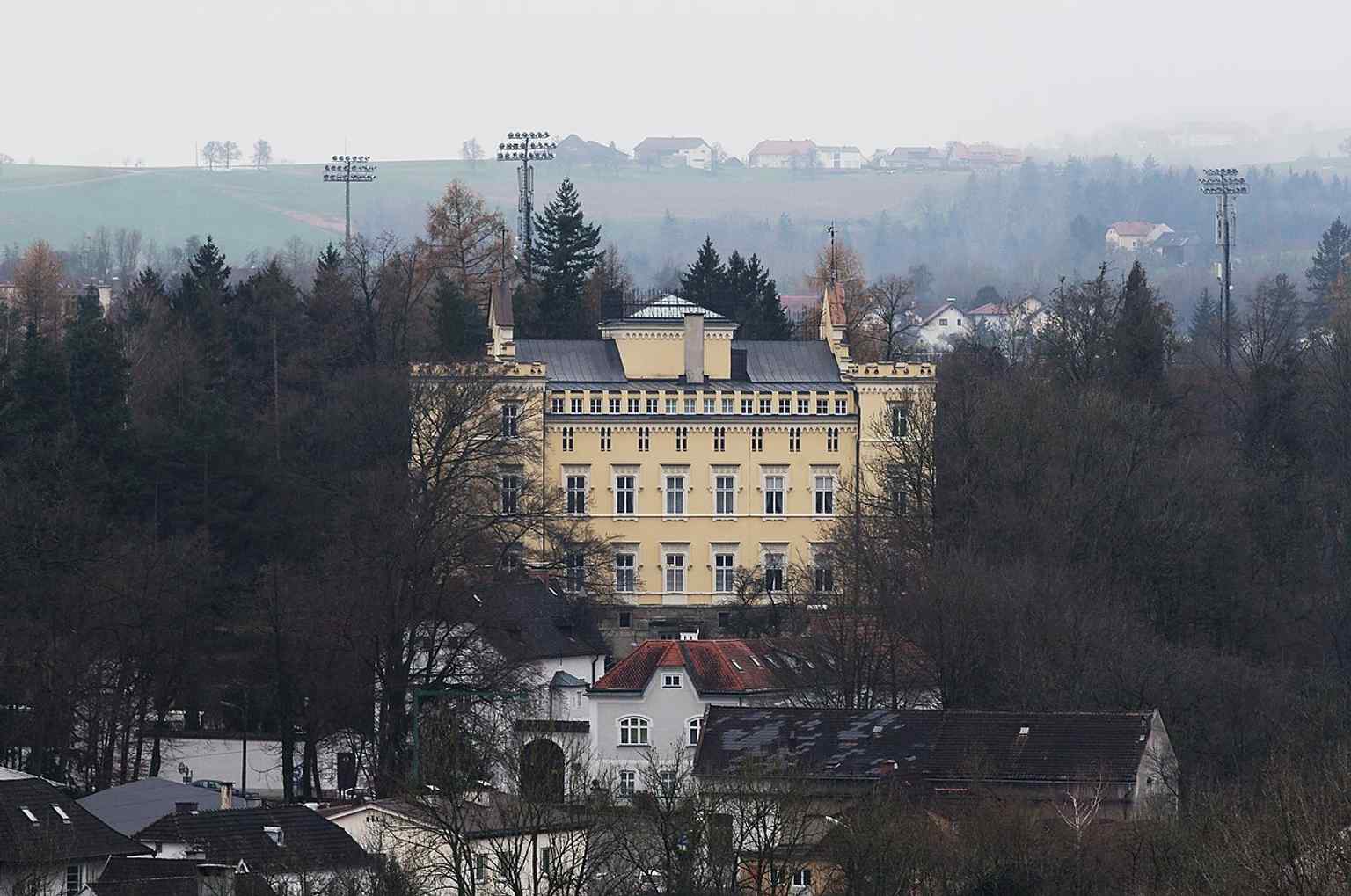 A wider streetscape view that shows how the castle sits along the ceremonial Preuenhueberstraße approach in Steyr.