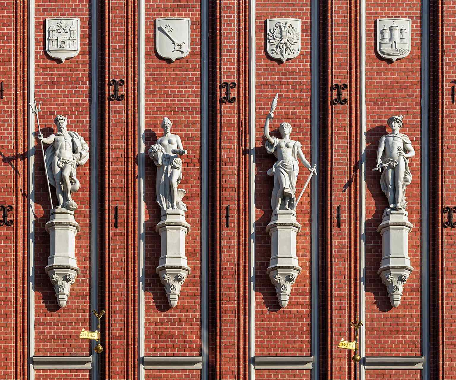 Close-up of the gable sculptures and Hanseatic coats of arms, highlighting the symbols of maritime trade and the merchant world that shaped the brotherhood.