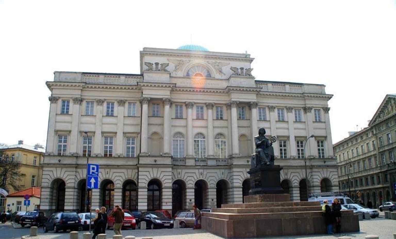 Wide composition with the Staszic Palace and the Copernicus statue together, matching the landmark’s historic placement before the palace.