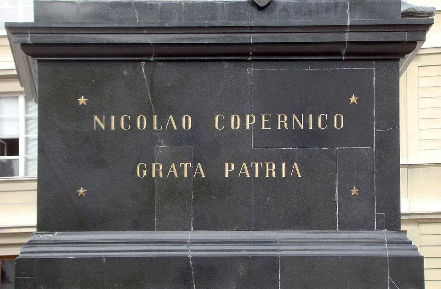 The Latin side of the pedestal reads 'Nicolao Copernico Grata Patria' — a direct reference to the monument’s bilingual inscriptions.