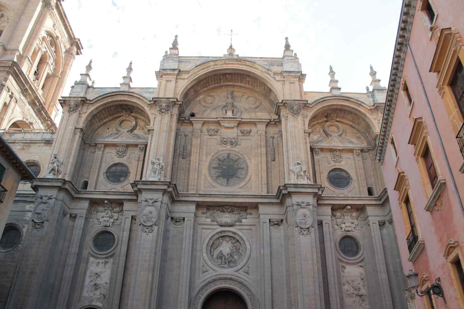 The cathedral's striking facade, designed by Alonso Cano, showcases Baroque elements and a triumphal arch structure, a masterpiece that took 181 years to build.