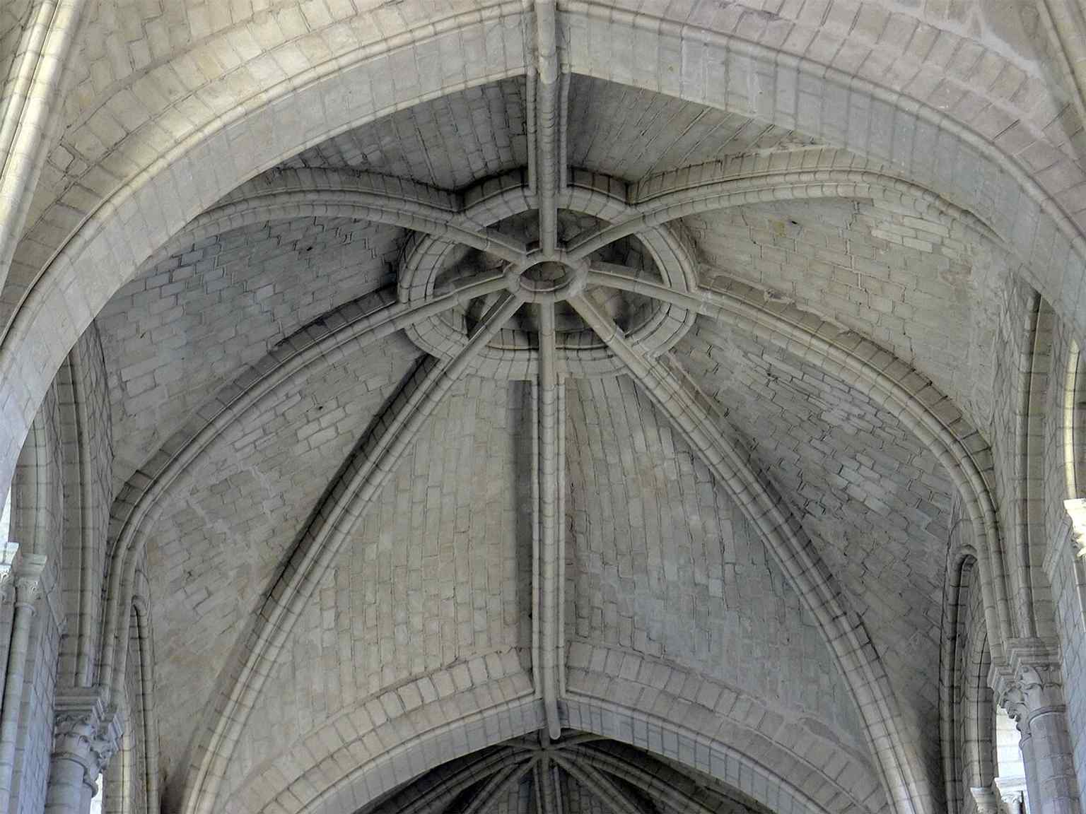 Close-up of the nave's unique vaulting, showcasing its irregular ribs and different keystones, including a remarkable 'suspended keystone,' characteristic of the 'first Angevin Gothic' style.
