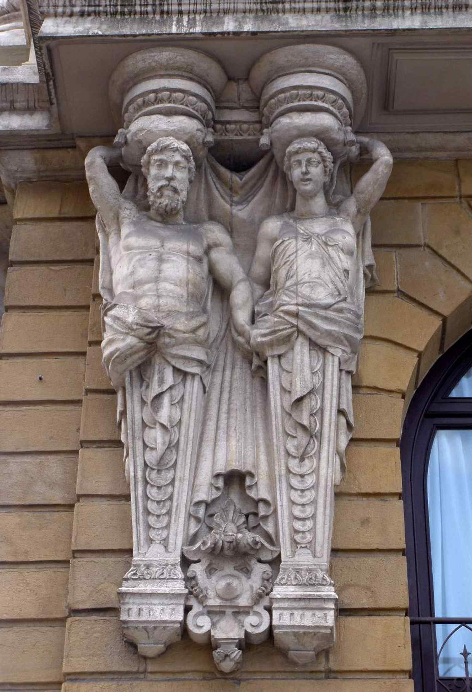 A close look at the caryatids on the façade — the sculpted figures that gave the theatre its playful nickname, “the maternity house.”