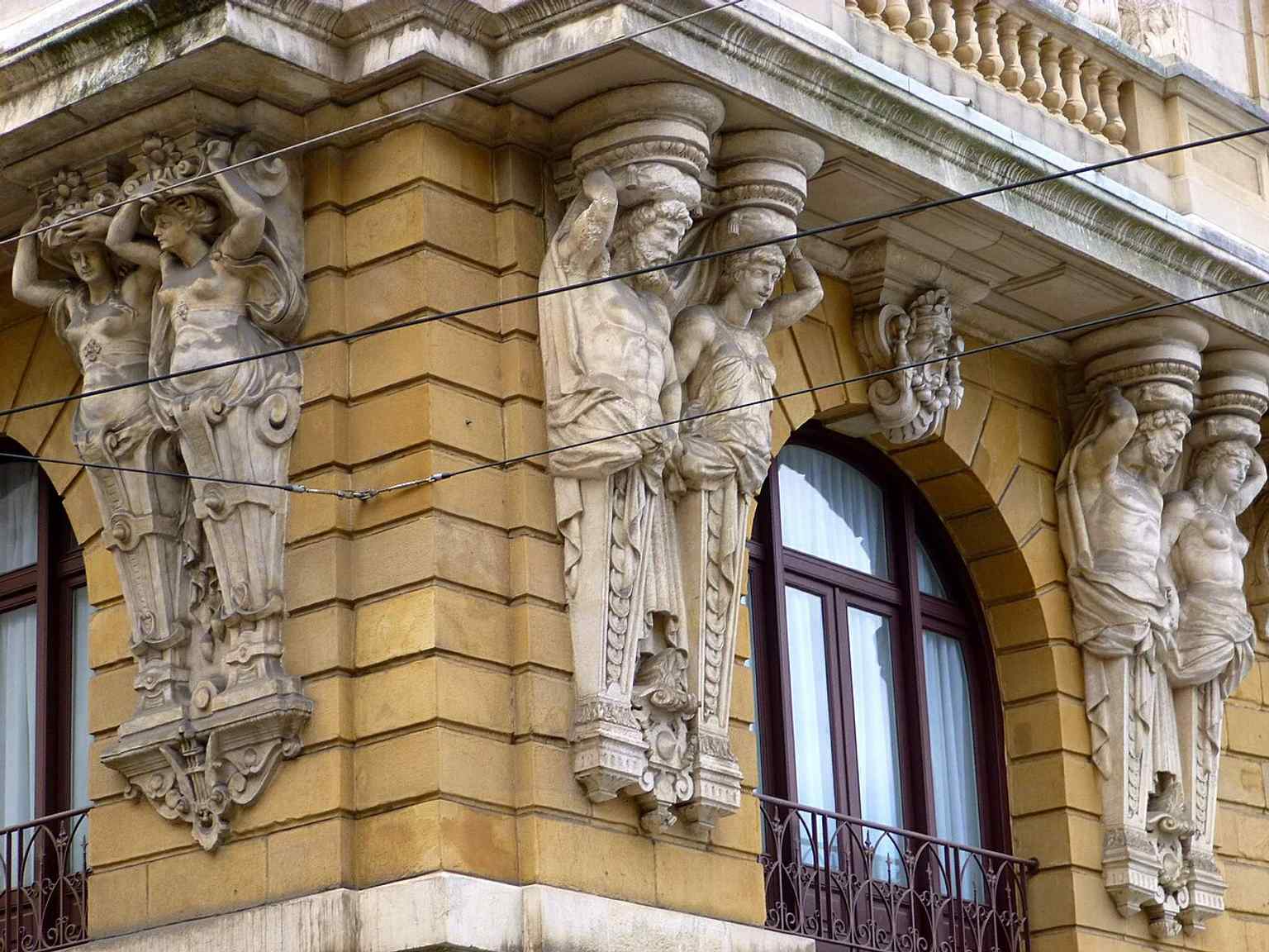 One of the façade’s atlantes, reflecting the richly decorated lower and middle sections described in the building’s architecture.