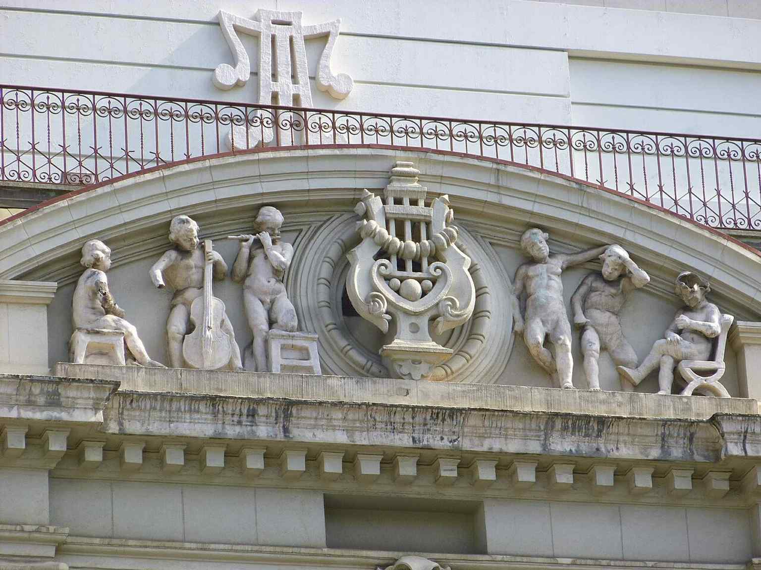 A decorative tympanum detail from the exterior, highlighting the theatre’s elaborate neobaroque ornament and sculptural finish.
