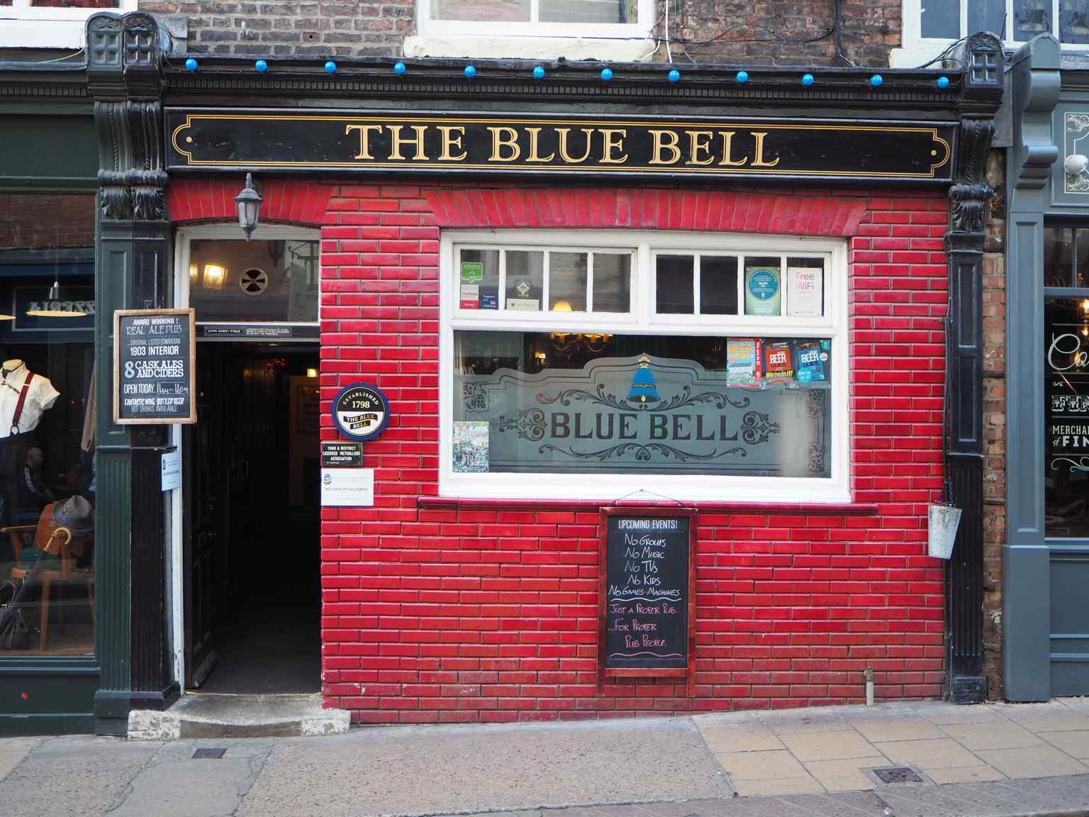 The slender red-brick facade and hanging sign of The Blue Bell on Fossgate (2018).