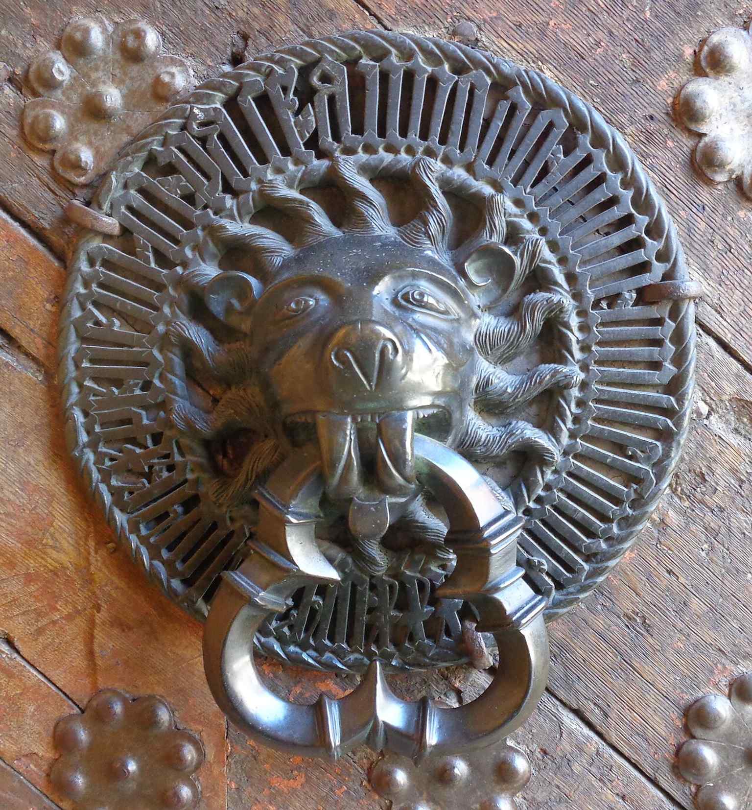 The right-hand door hammer on the main portal, one of the building’s finest surviving details from the 1430s.