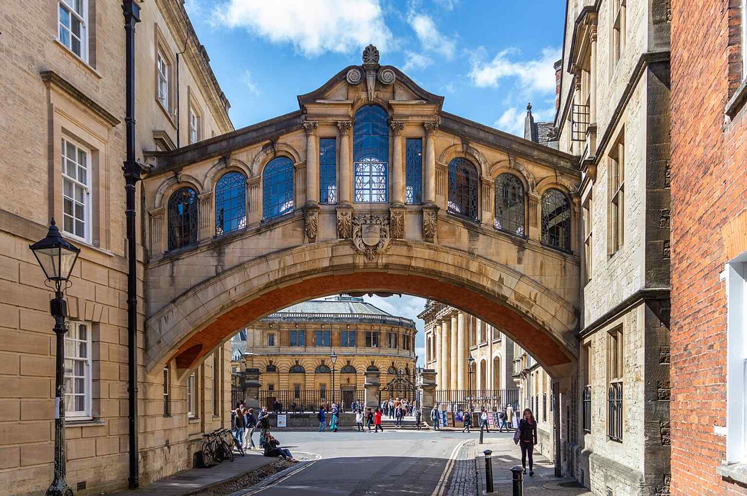 The east side of the bridge over New College Lane, with nearby college buildings and Oxford landmarks in the background.
