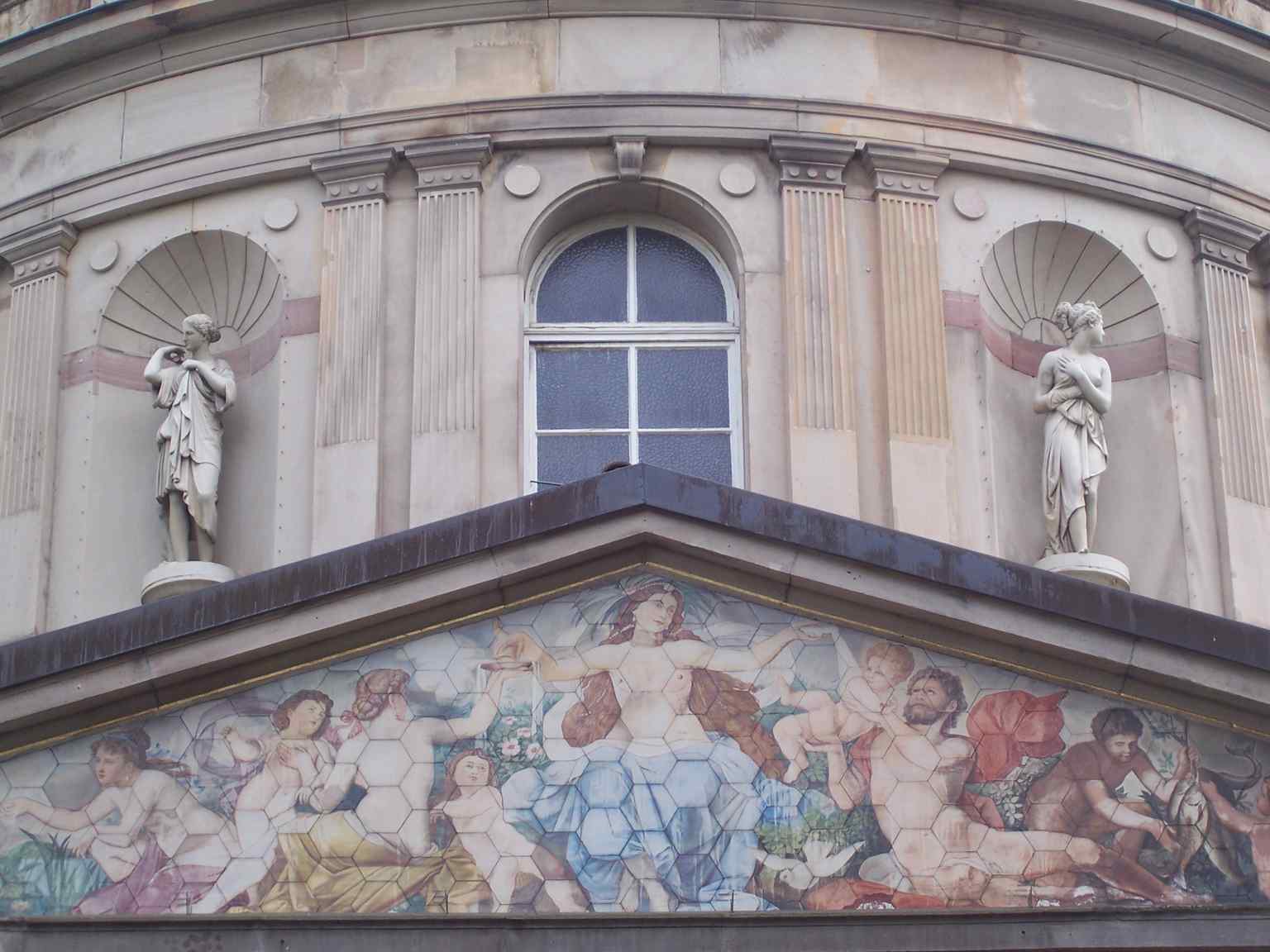 The Hygieia depicted in the gable above the Vierordtbad entrance, mirroring the goddess of health honored by the fountain below.
