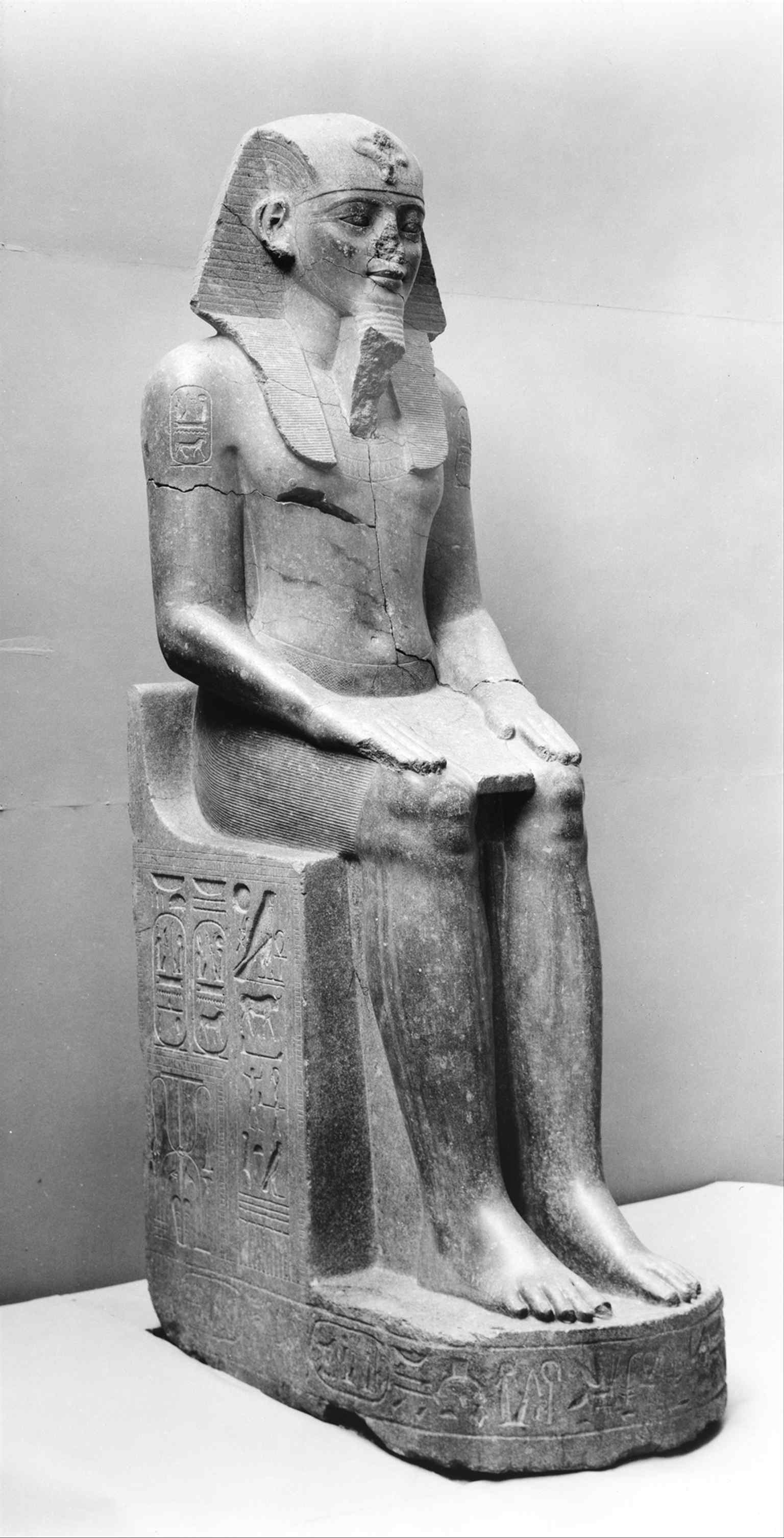 One of the colossal statues of Amenhotep III in the Egyptian galleries nearby, echoing the wing’s broader context of monumental ancient art.