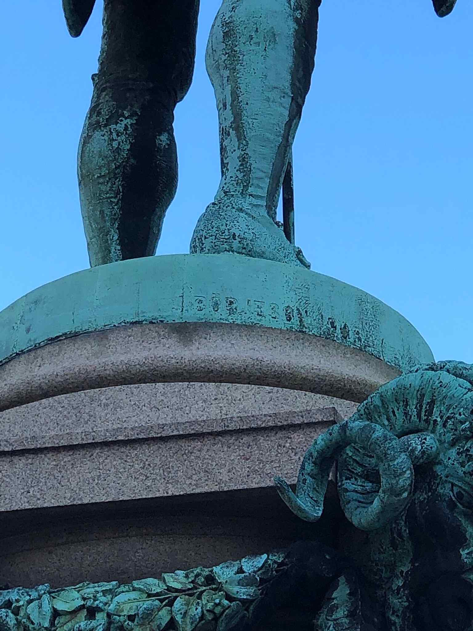 A close-up of the signature of John Börjeson, the sculptor of the Jonas Alströmer statue located at Lilla Torget.