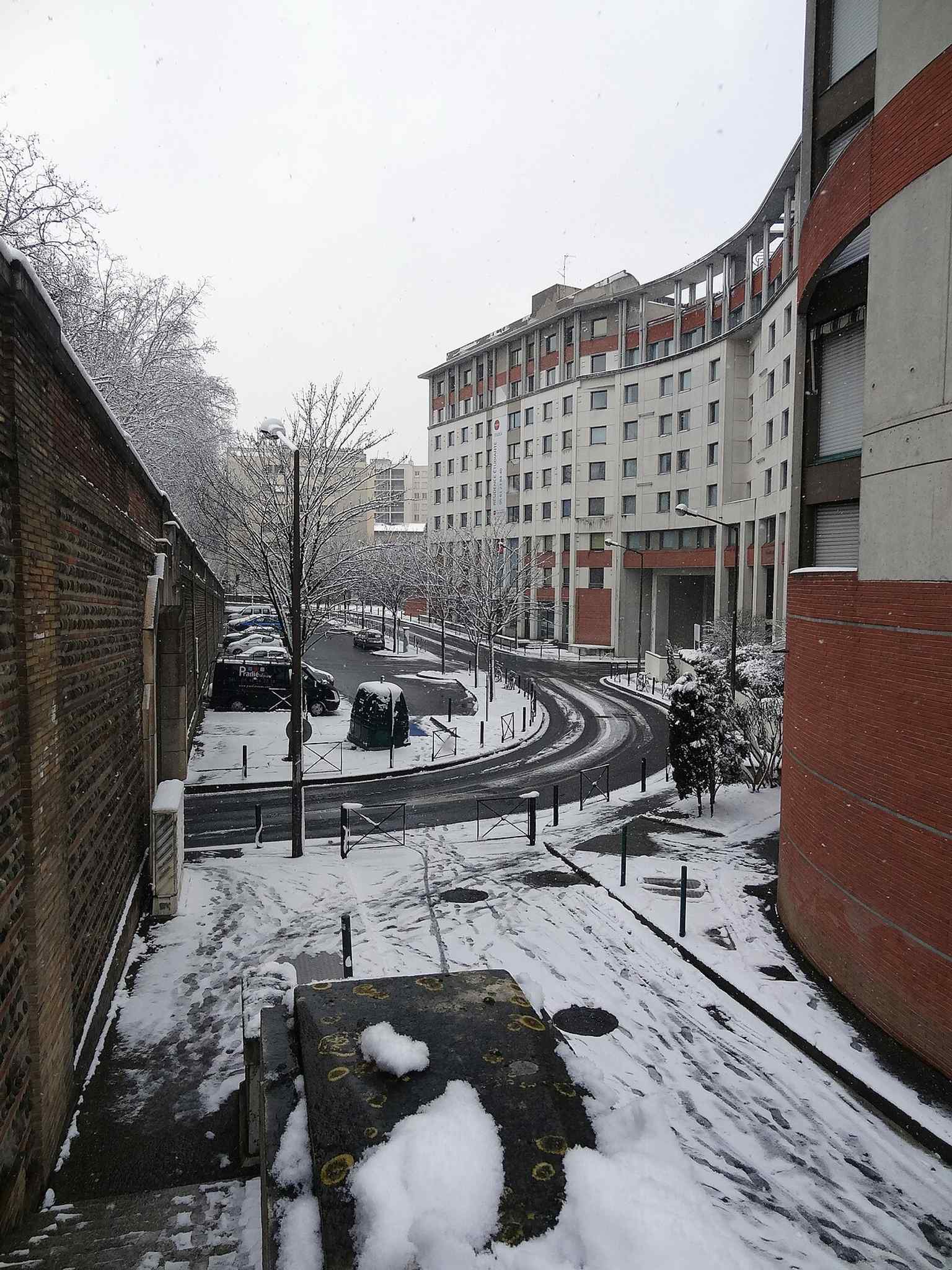 The avenue under winter snow, giving a clear view of the modern street that grew out of the former access road to Toulouse's Bazacle velodrome.