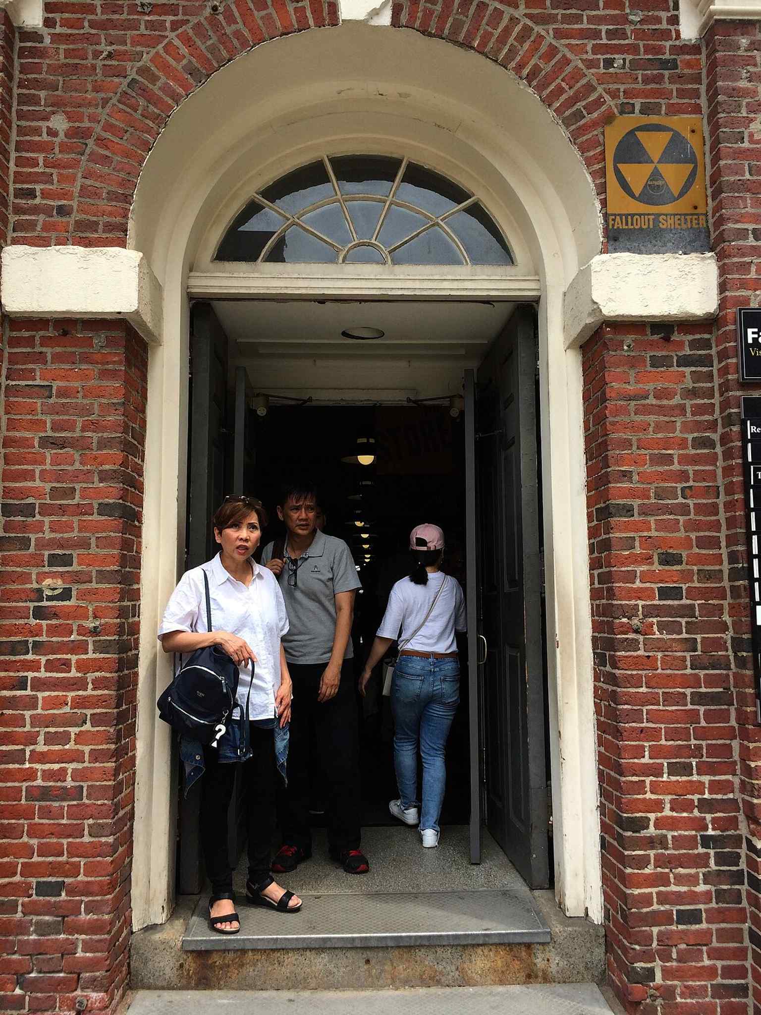 A modern entrance detail with a fallout-shelter sign — a small reminder that Faneuil Hall kept adapting through the 20th century.