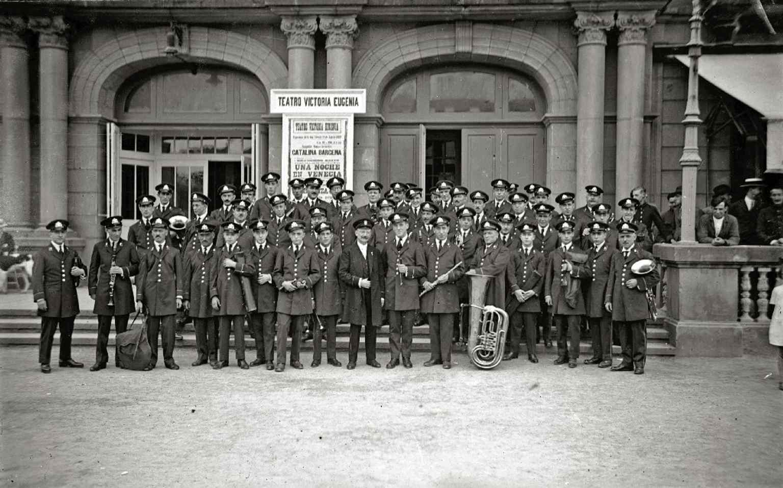 A historic black-and-white image of a band performing outside the theatre, evoking its long role in civic and musical life.