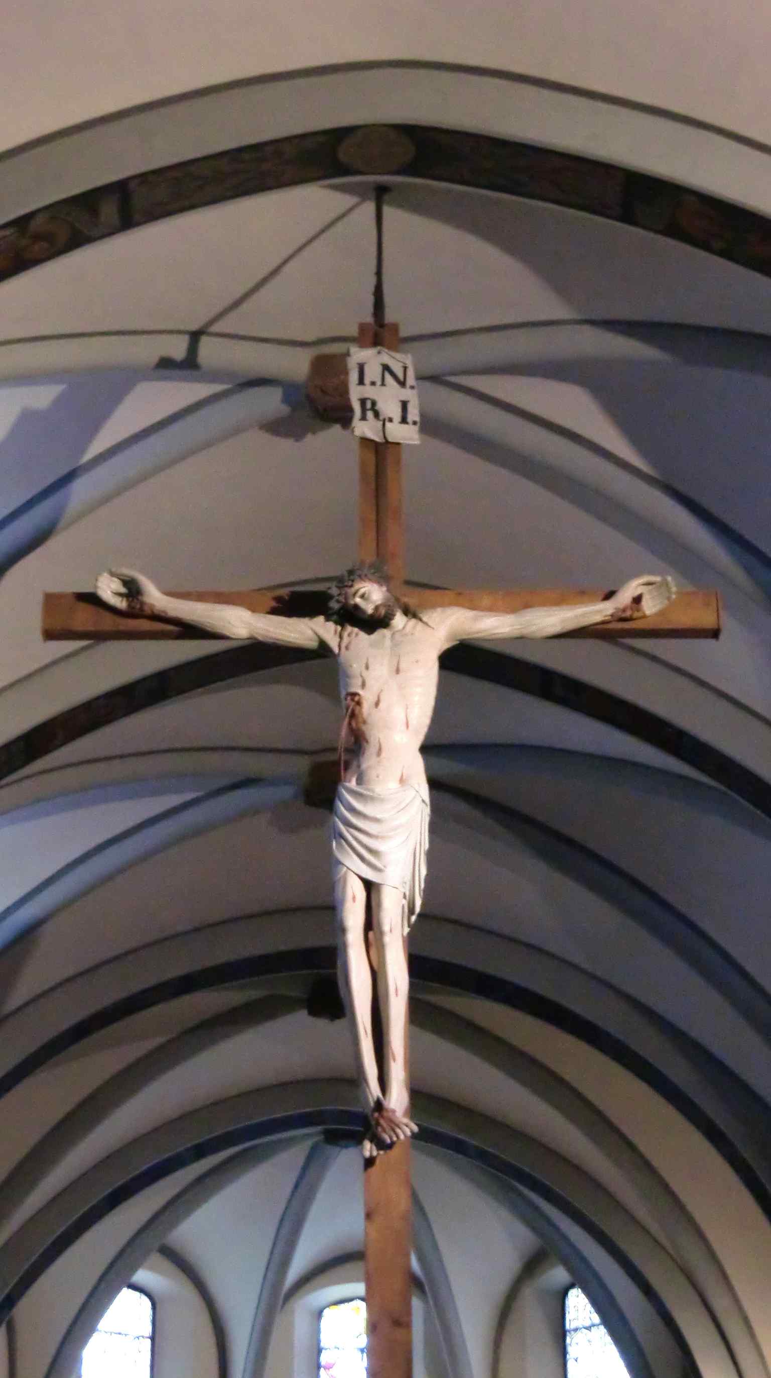 The 'magnam crucem', a dramatic painted wooden crucifix commissioned in 1397, hangs in the central nave against the backdrop of the cross vaults added in the late 15th century.