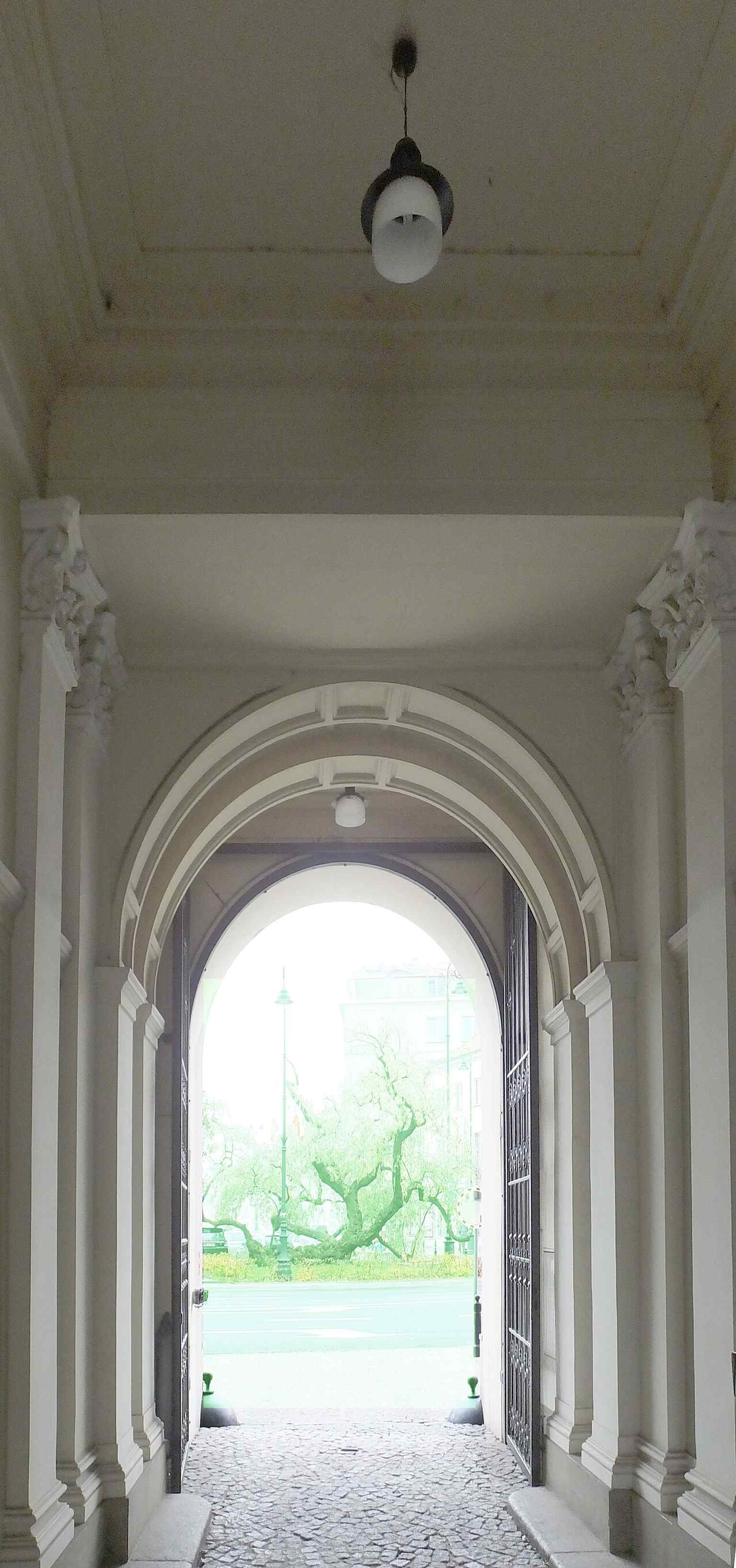 The passageway and façade details give a sense of the building as lived-in urban fabric, not just a monument.