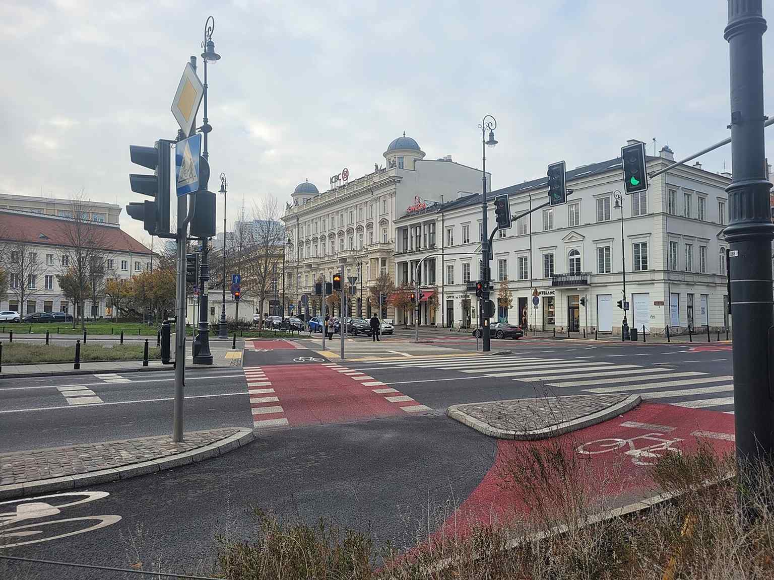 A wider context view of Plac Trzech Krzyży and the corner parcel that makes the building stand out in the streetscape.