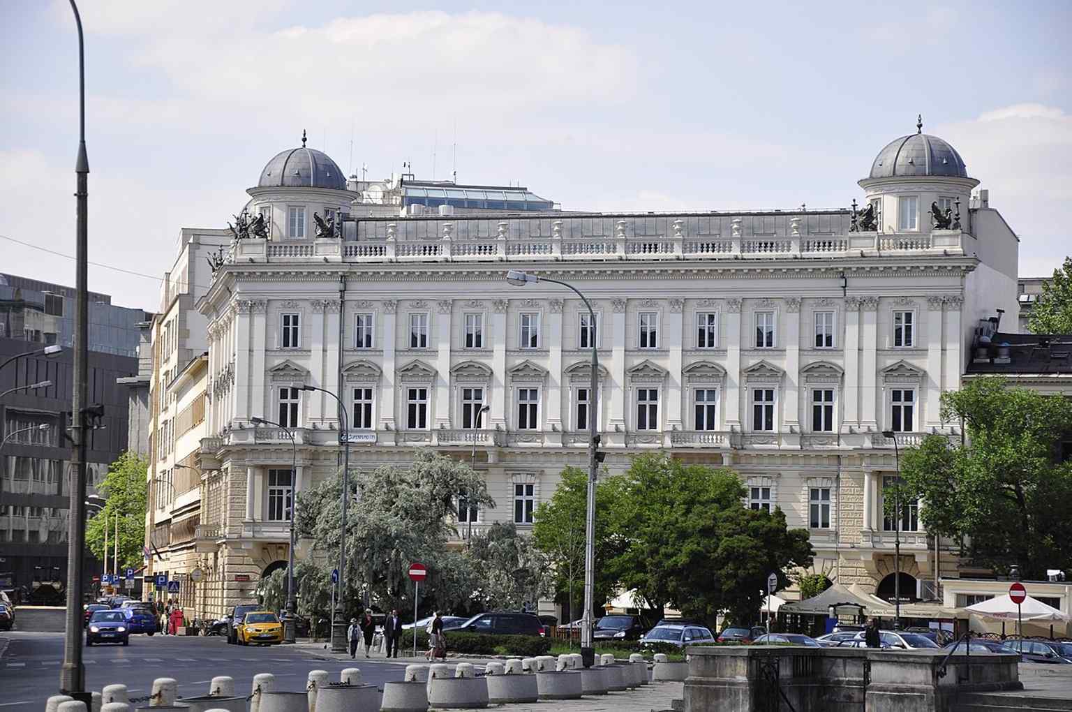 A full-height view of Pod Gryfami on Plac Trzech Krzyży 18, useful for seeing the 5-storey massing and mansard roof.