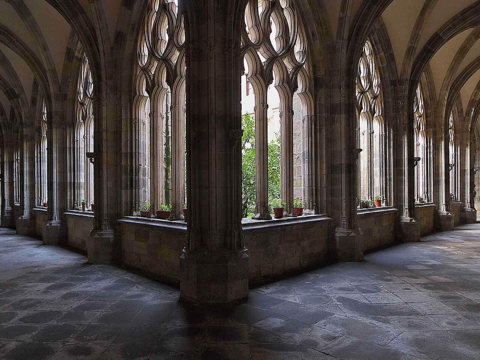 The cloister of Santiago Cathedral, a rare Gothic cloister in Biscay, later enriched with Neo-Gothic pinnacles, tracery, and gargoyles.