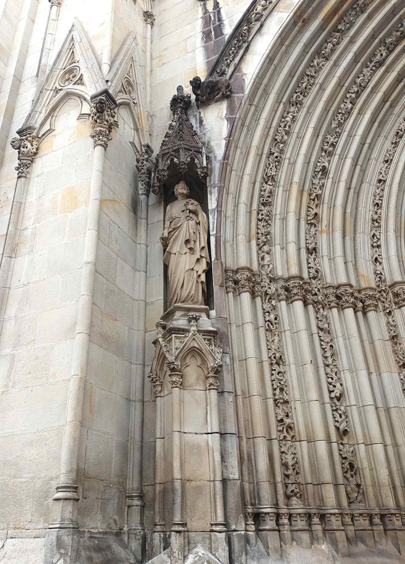 A sculpted figure in the cathedral’s western doorway, reflecting the ornate portal imagery that greets visitors at the main entrance.