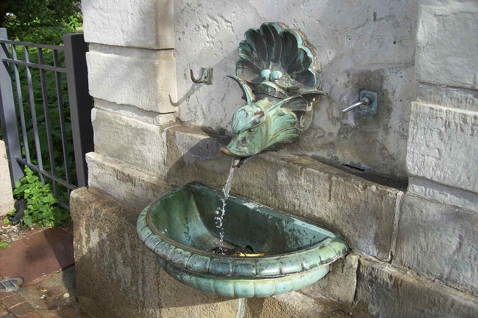 Water gracefully streams from the mouth of the ornamental 'water monster', symbolizing the Kallebäcks källa pipeline that fed the well.