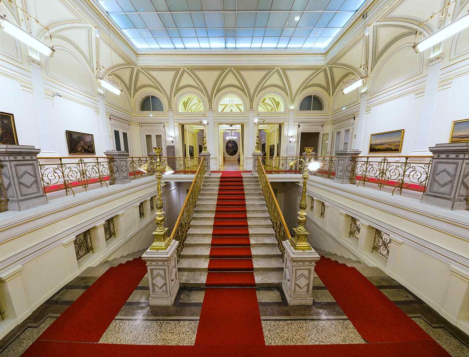 The grand staircase is part of the Narodni dom's interior, which was originally a lively social hub with a restaurant, dance hall, and even a gymnasium, now home to the National Gallery of Slovenia.