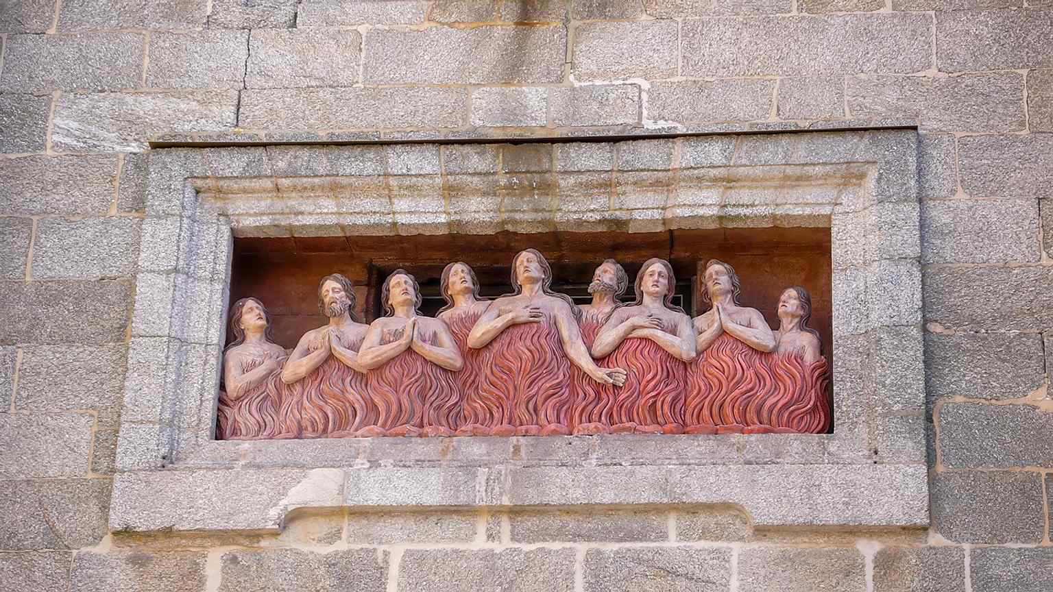 This dramatic relief above the main door depicts souls in flames, inspiring a local legend that the sculptor Manuel de Prado immortalized the faces of greedy cofrades among the condemned.