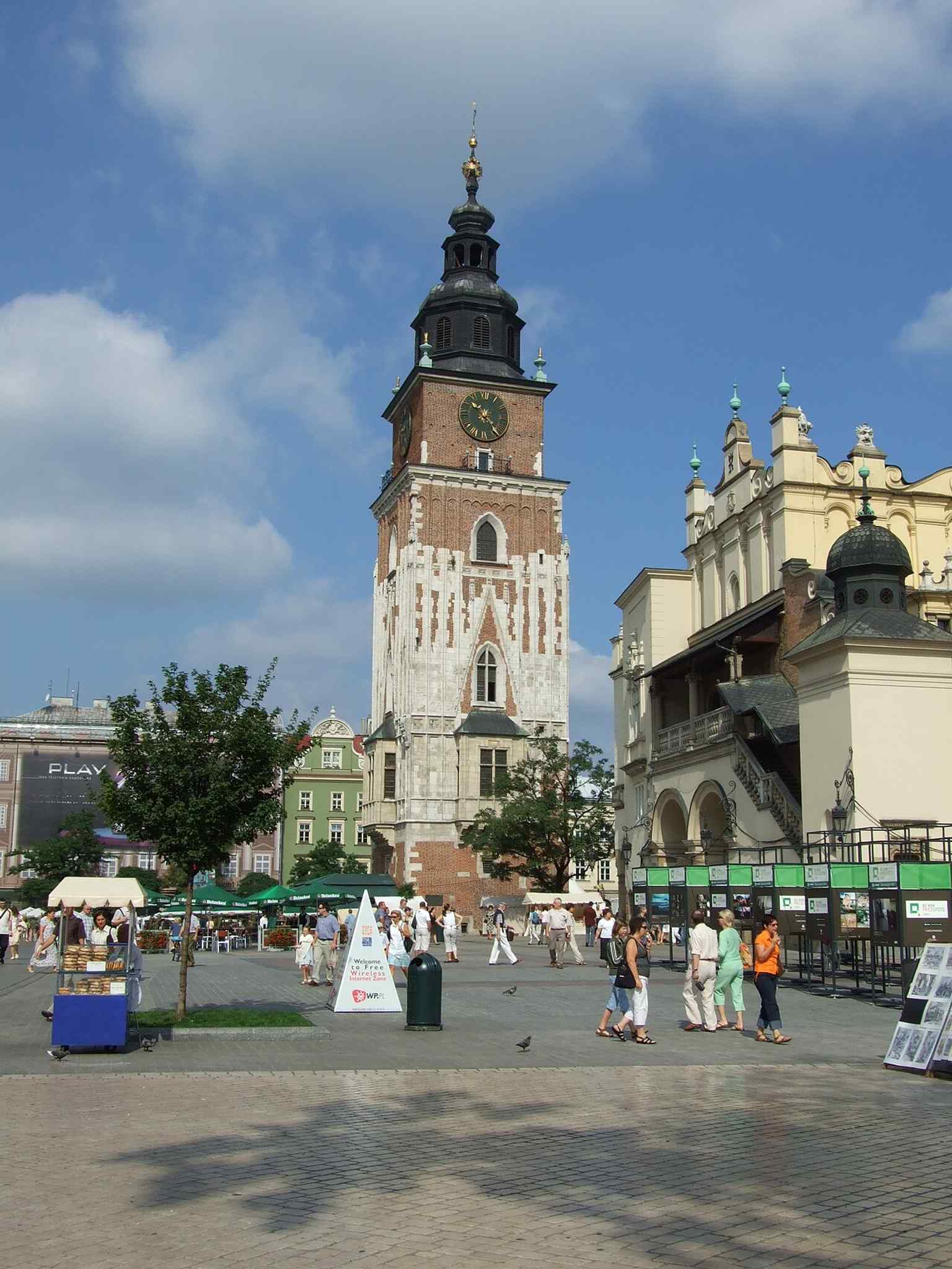 The tower from the Rynek, showing its distinctive Gothic silhouette and the famous slight lean that gives this landmark its character.