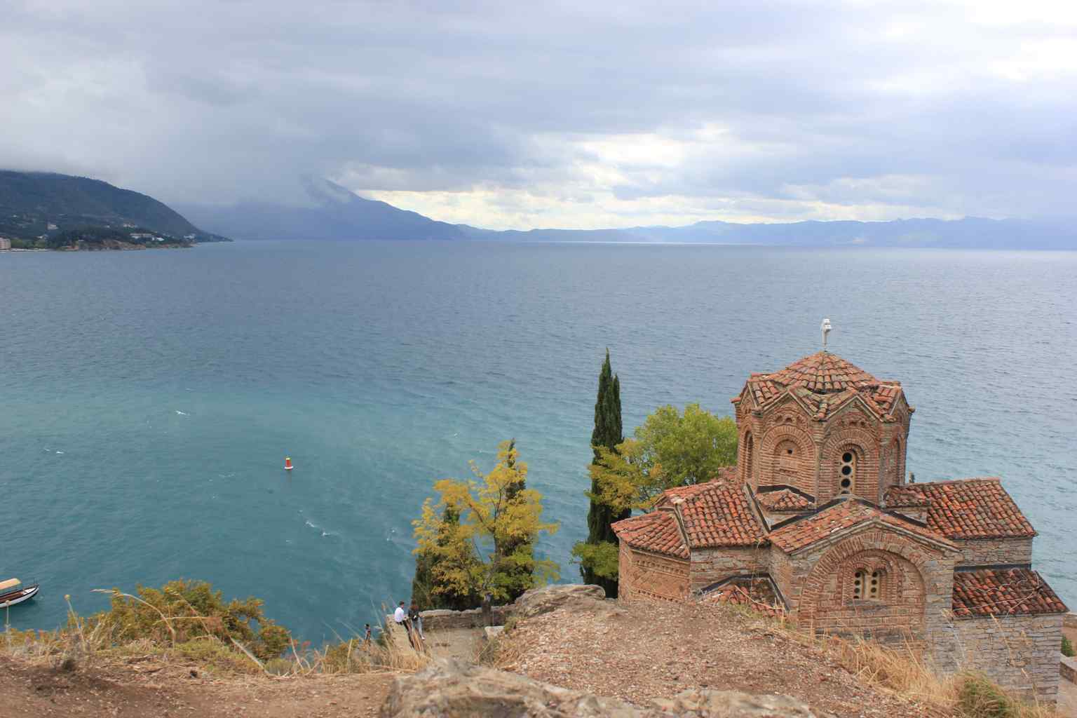 Perched dramatically on a rocky hill above Lake Ohrid, the church's name "Kaneo" is thought to derive from the Latin for "silvery," referencing the lake's shimmering waters below.