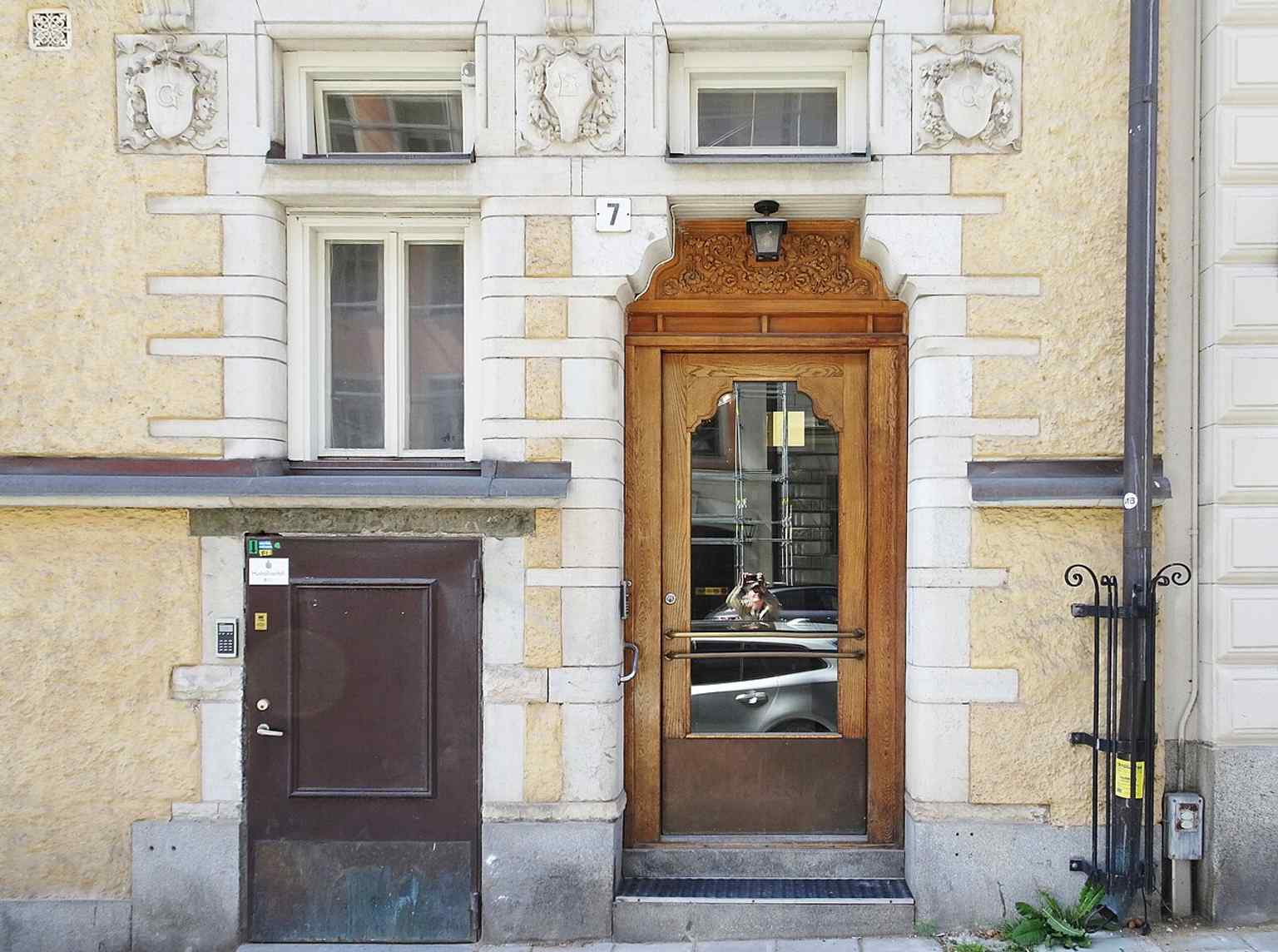 The main entrance highlights the building’s round stone portal and ornate doorway details, part of the cultured façade treatment that made this house stand out in the 1880s.