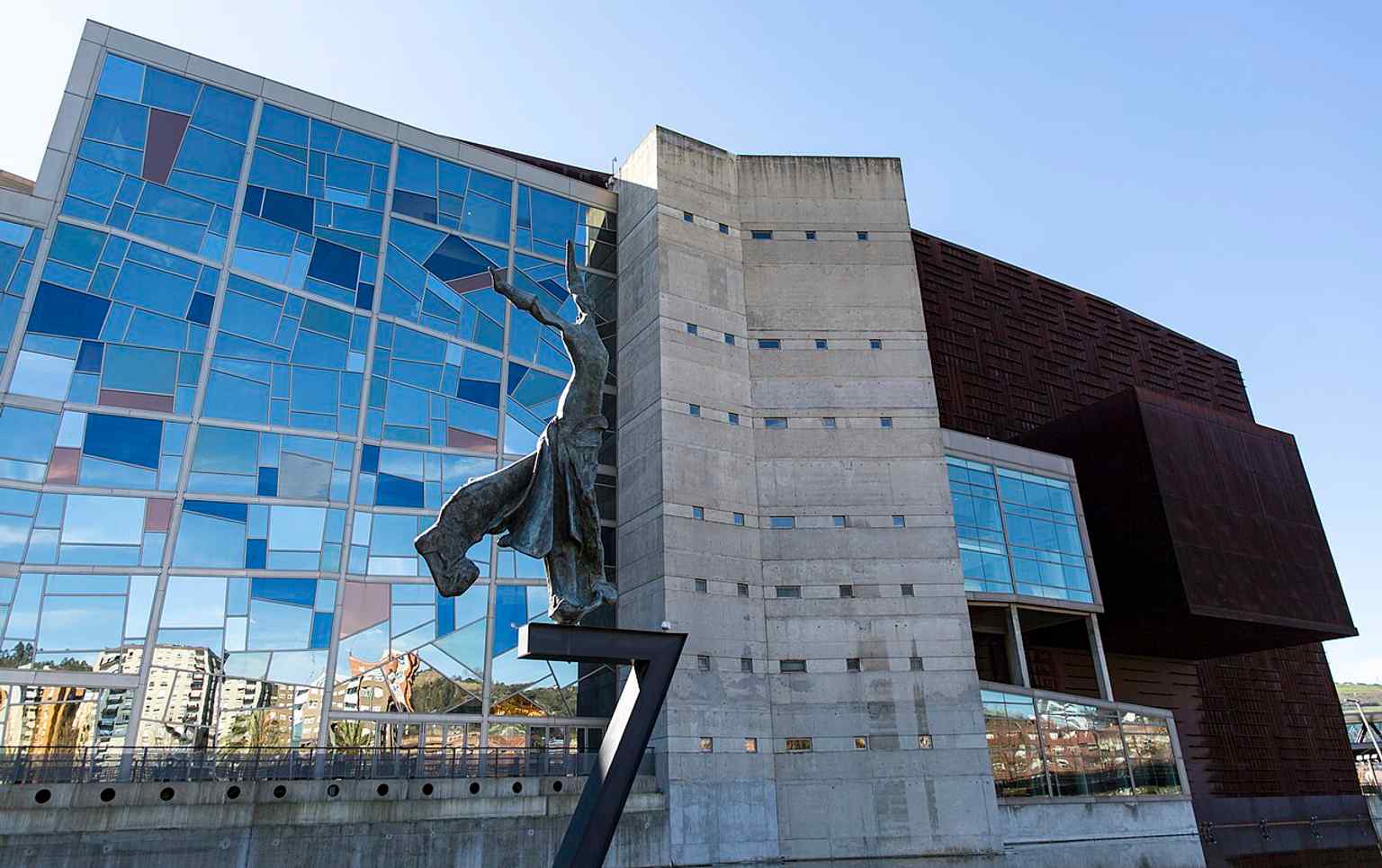 A high-resolution exterior of Euskalduna Palace, the corten-steel landmark built on the former Euskalduna shipyard site to echo a ship from Bilbao’s industrial past.