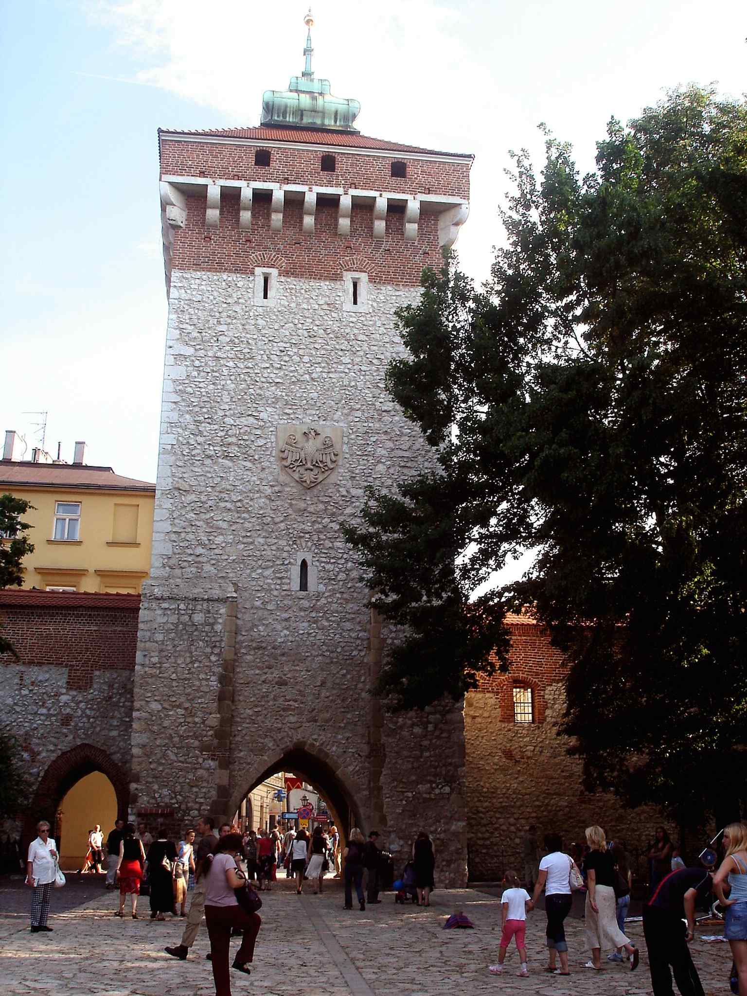 Die nächtliche Beleuchtung verleiht dem Turm eine dramatische Silhouette und unterstreicht, wie das mittelalterliche Tor noch immer die moderne Stadt verankert.