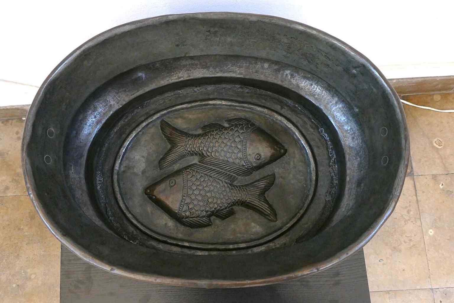 A ritual washing basin with fish ornament, one of the museum objects that helps tell the story of prayer and daily religious practice.