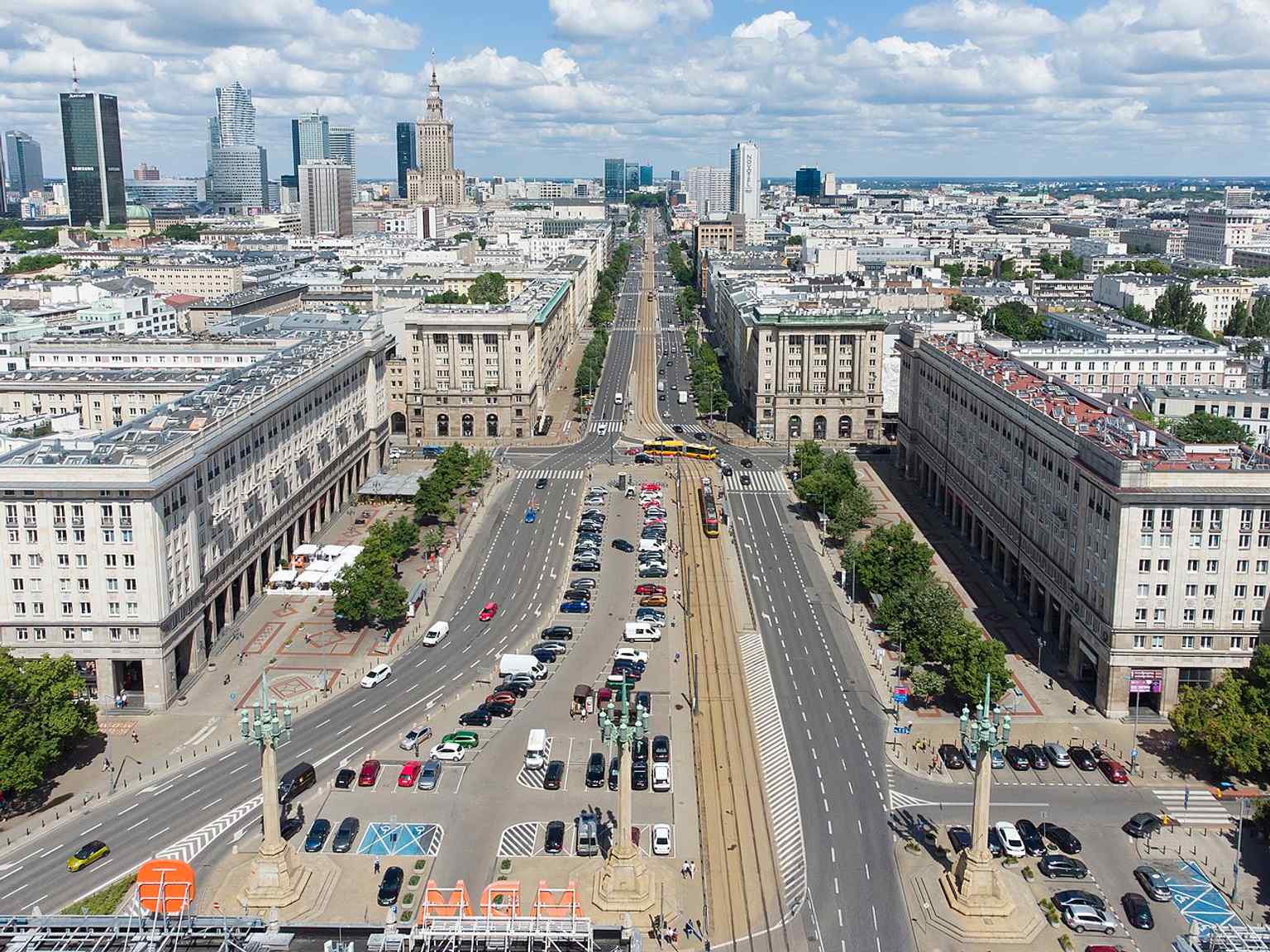 Drone view from the south, with Hotel MDM, Marszałkowska Street, and the square’s monumental symmetry all visible at once.