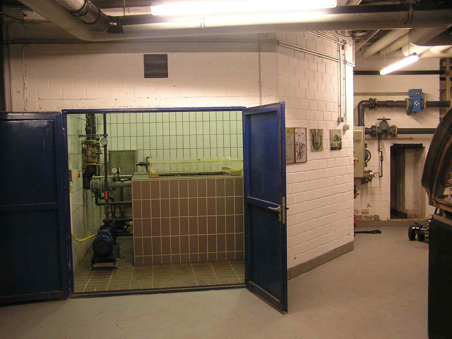 The interior of the Kaiserquelle's chamber, showing the original spring enclosure, which the 1990s 'Quellhaus' design made visible through a glass floor to honor the site's 2000-year history.