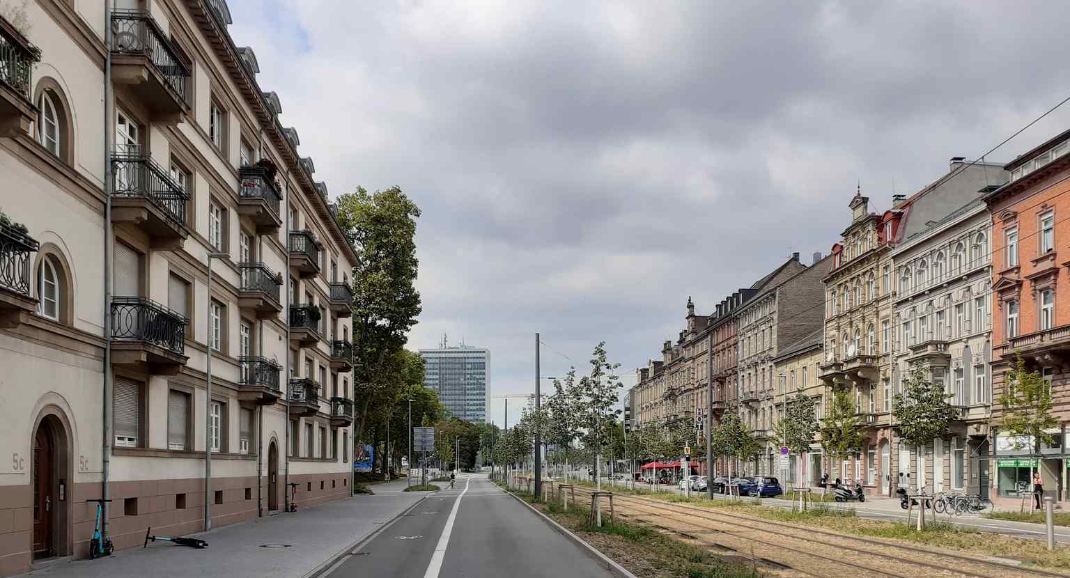 This image shows a section of the Kriegsstraße in 2022, featuring the former Badenwerk-Hochhaus from the 1960s, a prominent landmark at Ettlinger-Tor-Platz that was an outcome of the city's post-war expansion.
