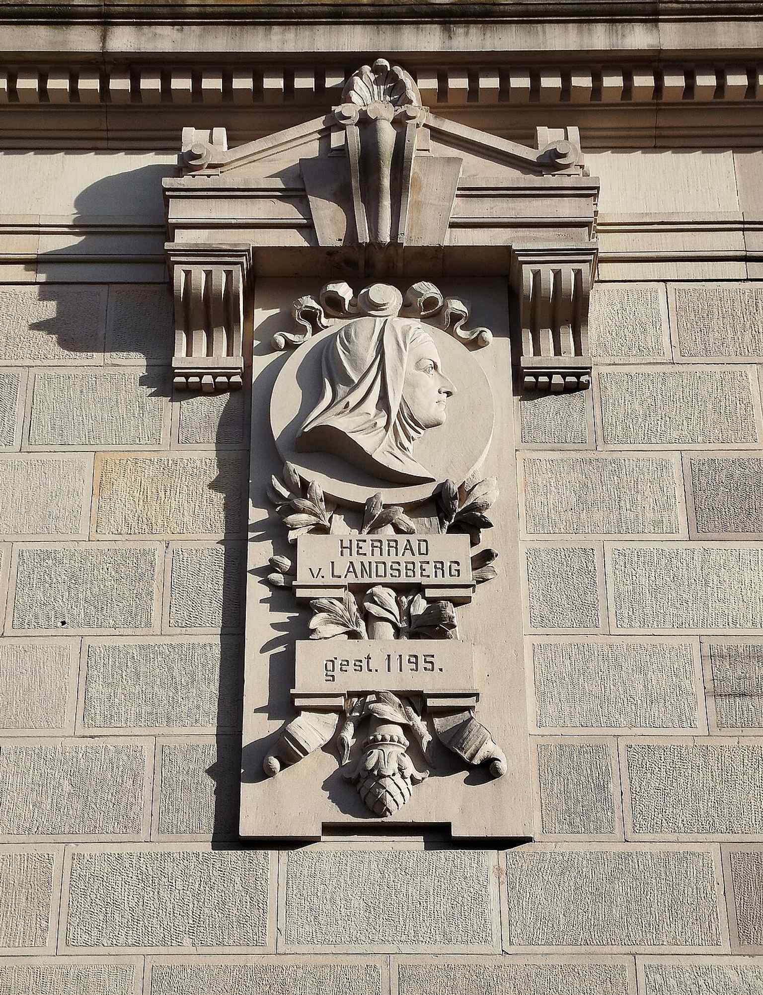 A sculpted medallion of Herrade of Landsberg, recalling the medieval manuscript heritage linked to Strasbourg’s lost and rebuilt collections.