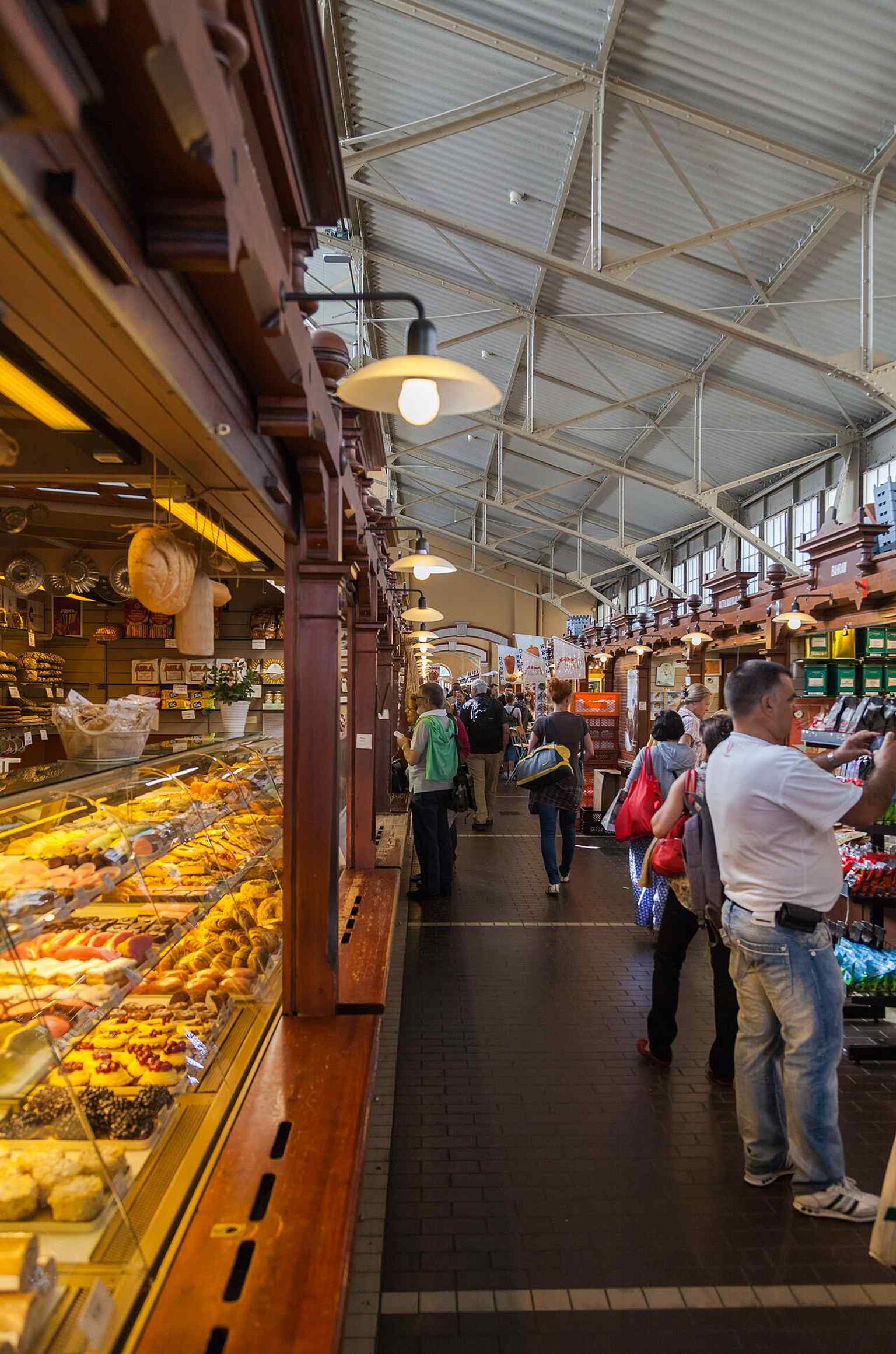 Inside the hall, where small food stalls and cafés keep the building’s original market atmosphere alive for lunch crowds and shoppers.
