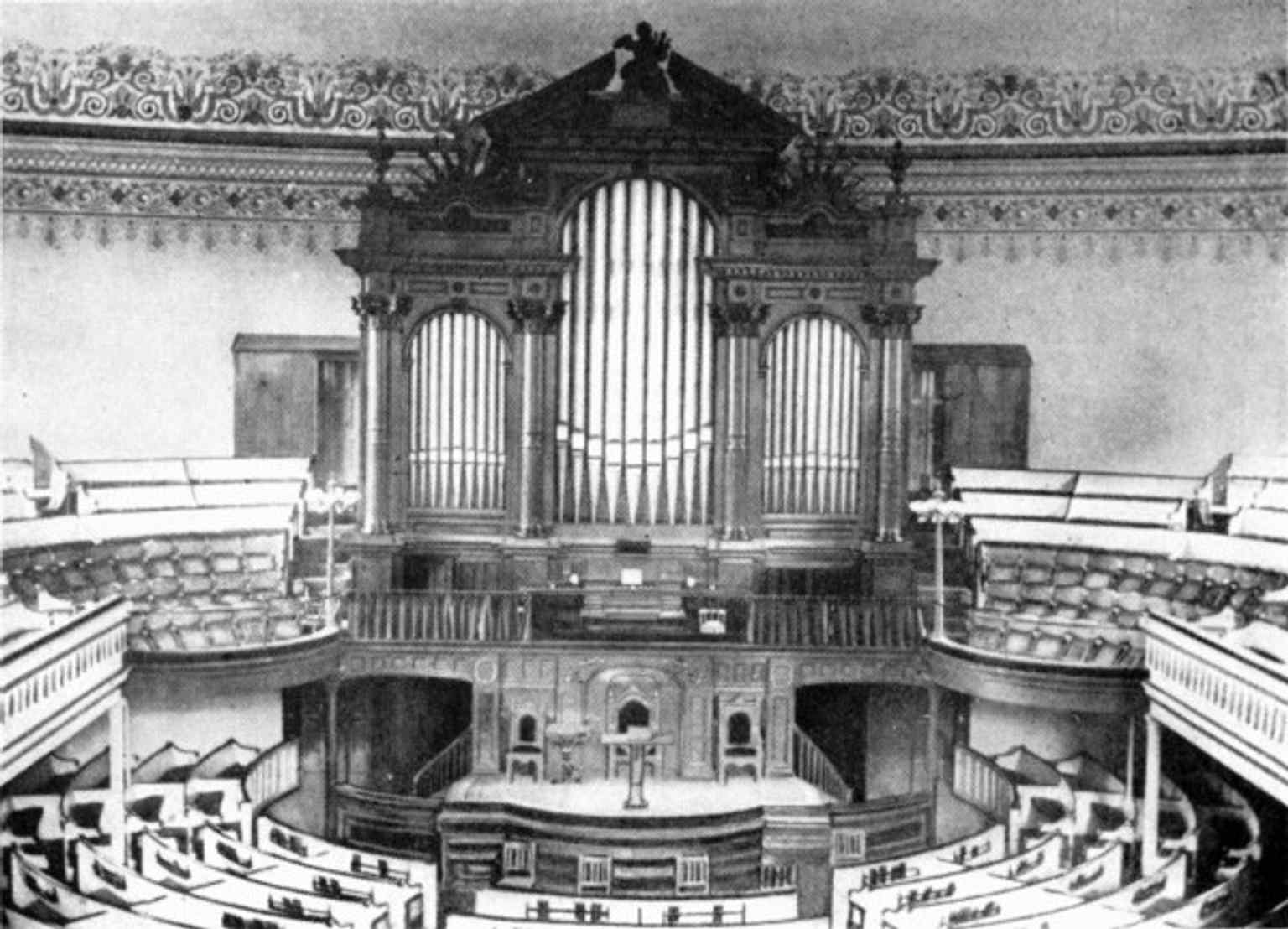 The main sanctuary's barn-like design with pews arranged in an arc, where Henry Ward Beecher delivered dramatic sermons and staged mock slave auctions to purchase the freedom of enslaved individuals.