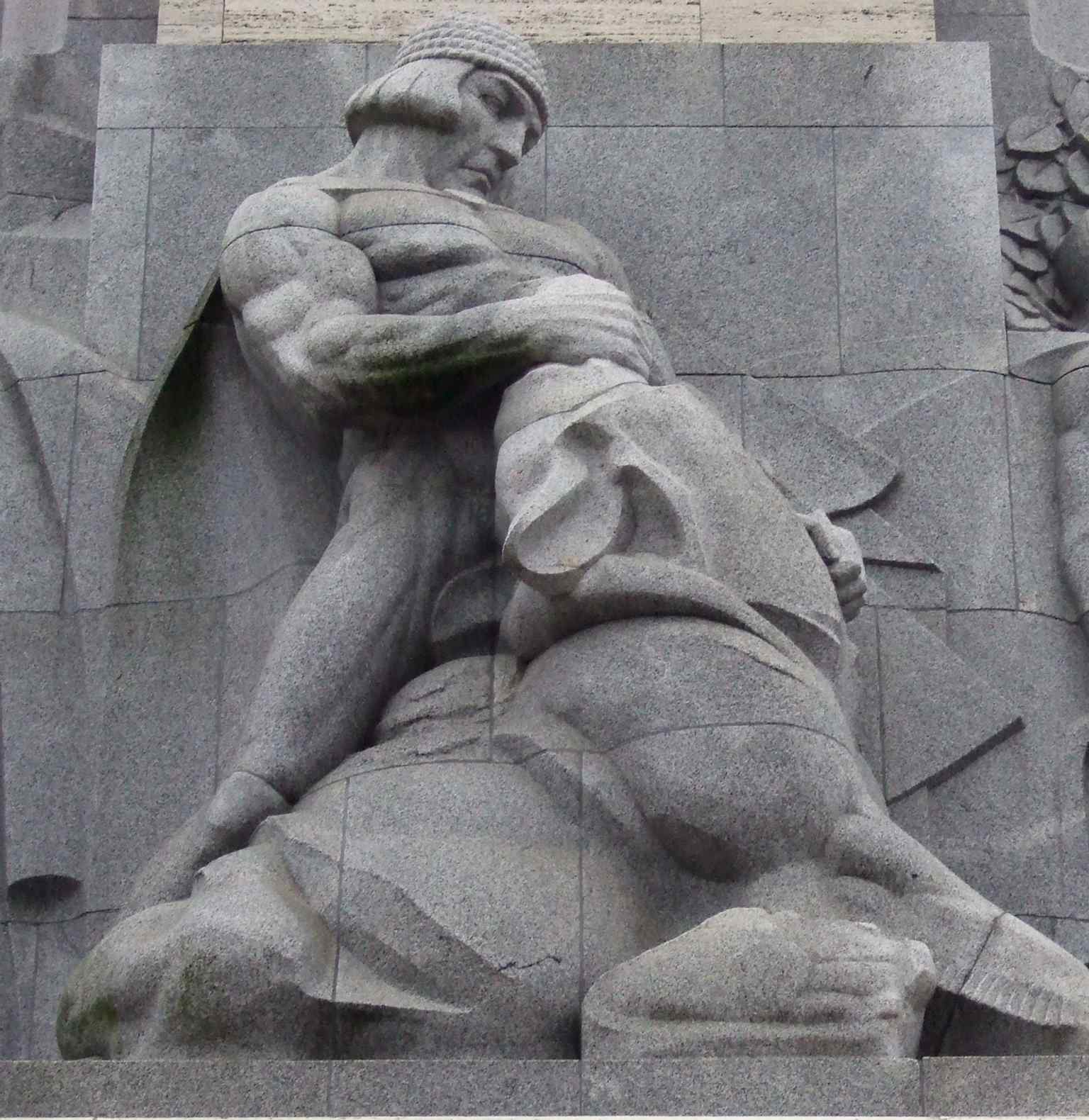 Lāčplēsis, the legendary Bear-Slayer, appears as one of the monument’s grey sculpture groups honoring Latvian heroic tradition.