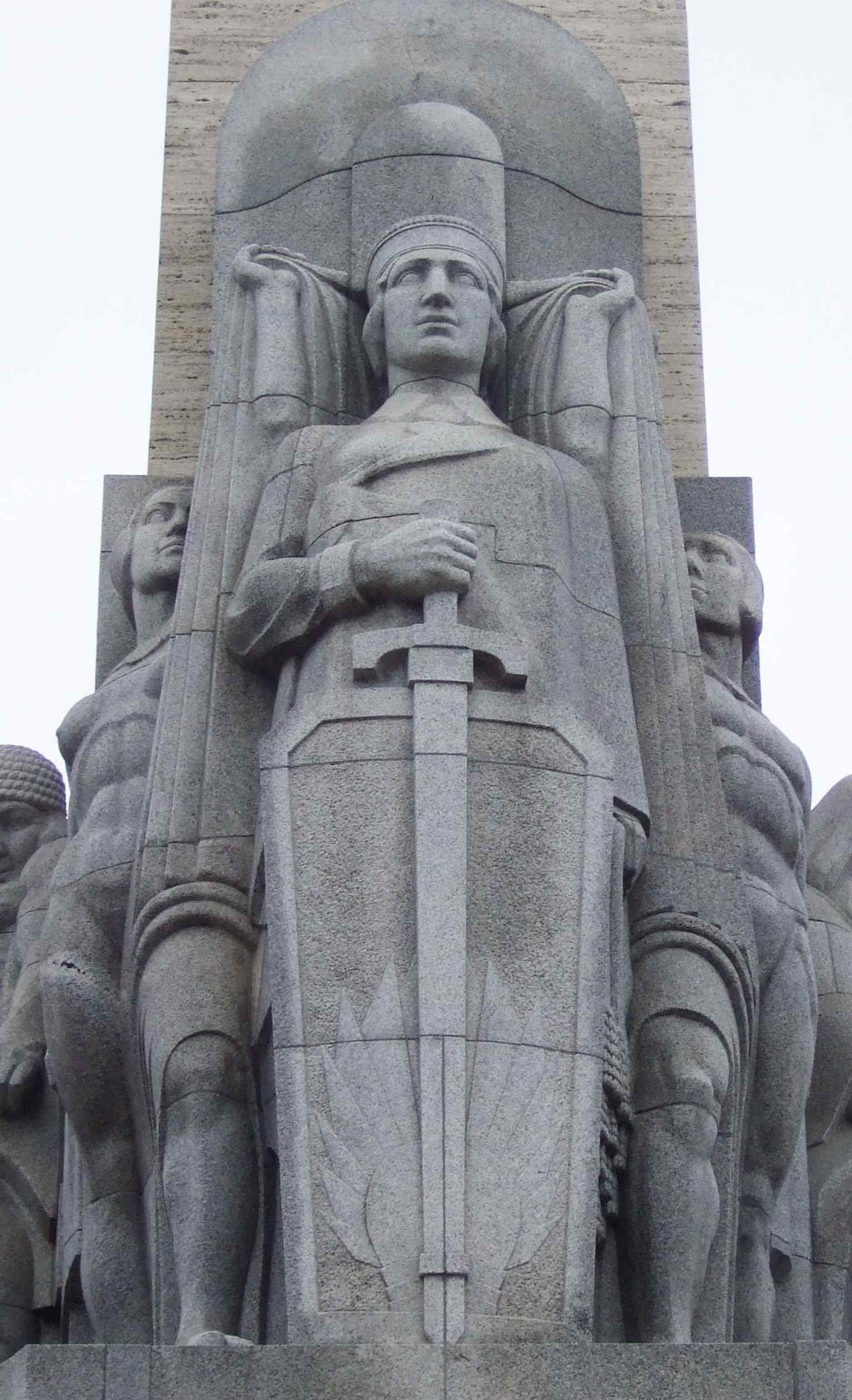 The ‘Latvia’ figure group at the base ties the monument to the nation itself and its post-independence identity.