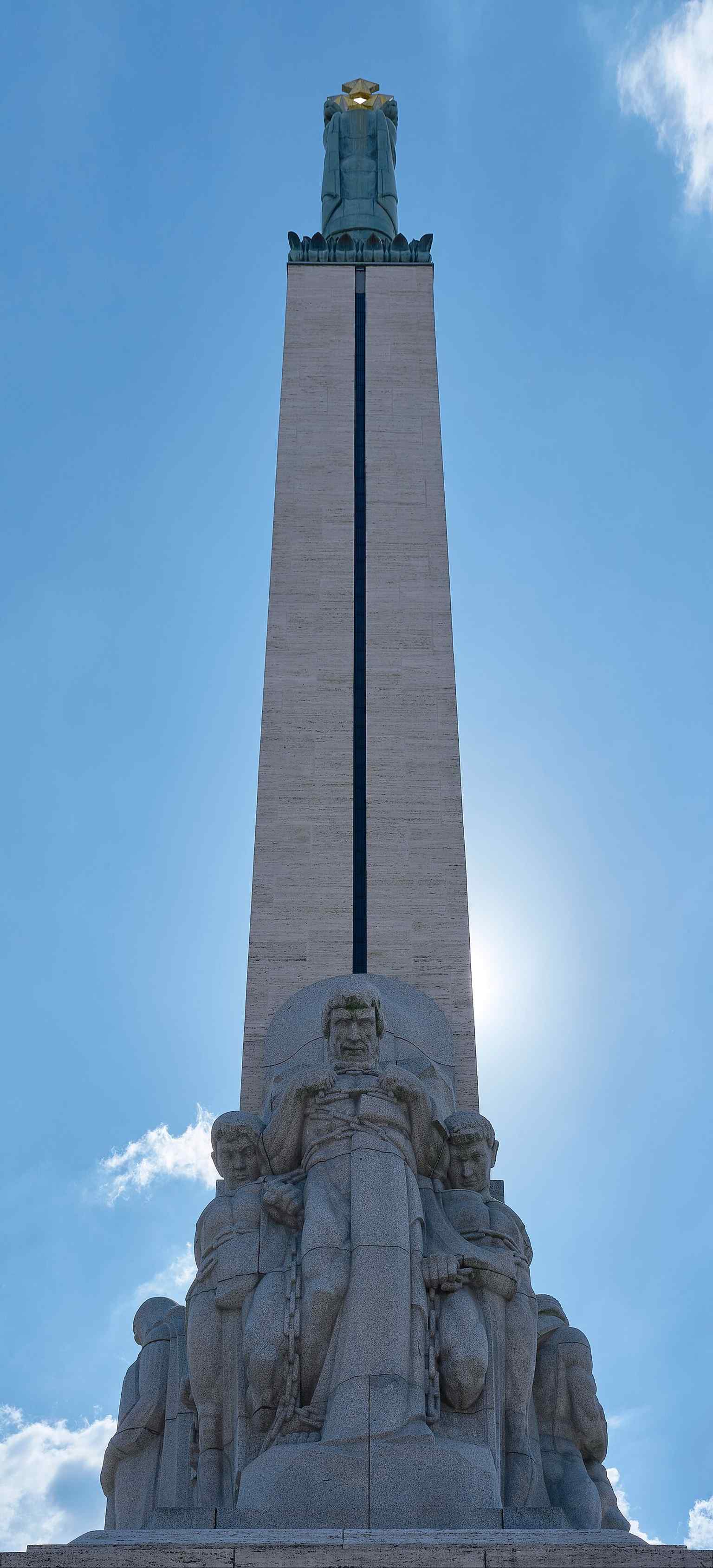 A back-side view that helps show the monument’s layered structure and the sculptural groups that surround its base.